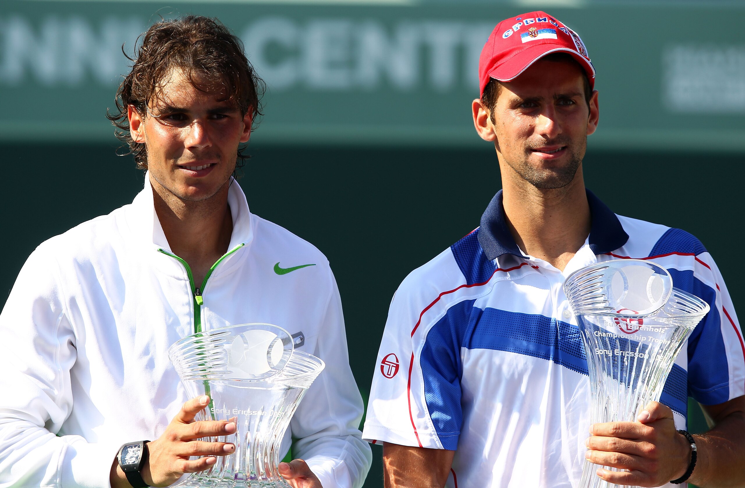 KEY BISCAYNE, FL - APRIL 03:  Novak Djokovic of Serbia celebrates with the trophy as Rafael Nadal (L) of Spain looks on holding the runner up trophy after Djokovic won the men's singles championship at the Sony Ericsson Open at Crandon Park Tennis Center