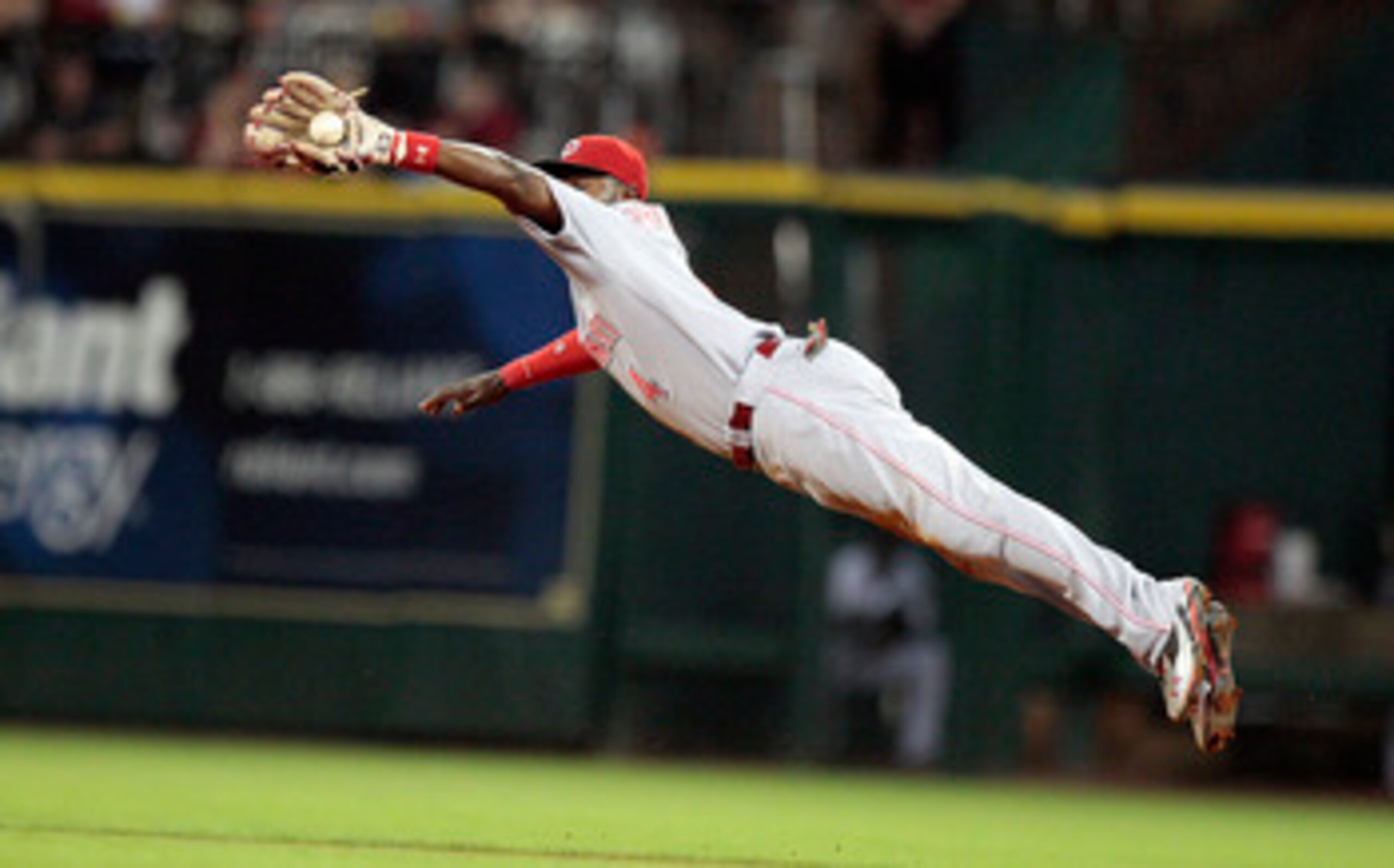HOUSTON - MAY 09:  Second baseman Brandon Phillips  #4 of the Cincinnati Reds makes a diving catch on a line drive against the Houston Astros at Minute Maid Park on May 9, 2011 in Houston, Texas.  (Photo by Bob Levey/Getty Images)