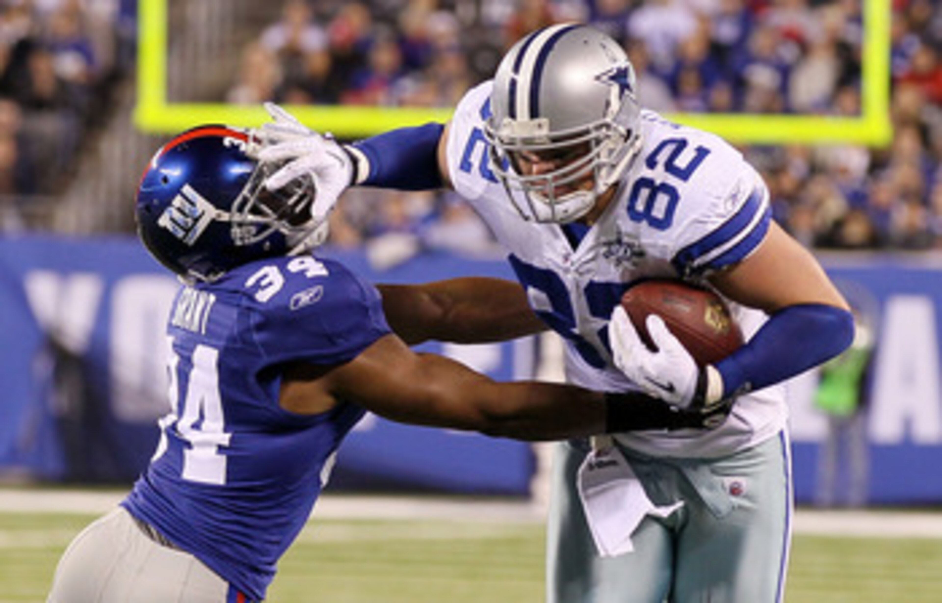 EAST RUTHERFORD, NJ - NOVEMBER 14: Jason Witten #82 of the Dallas Cowboys stiff arms Deon Grant #34 of the New York Giants as he runs the ball on November 14, 2010 at the New Meadowlands Stadium in East Rutherford, New Jersey.  (Photo by Jim McIsaac/Getty