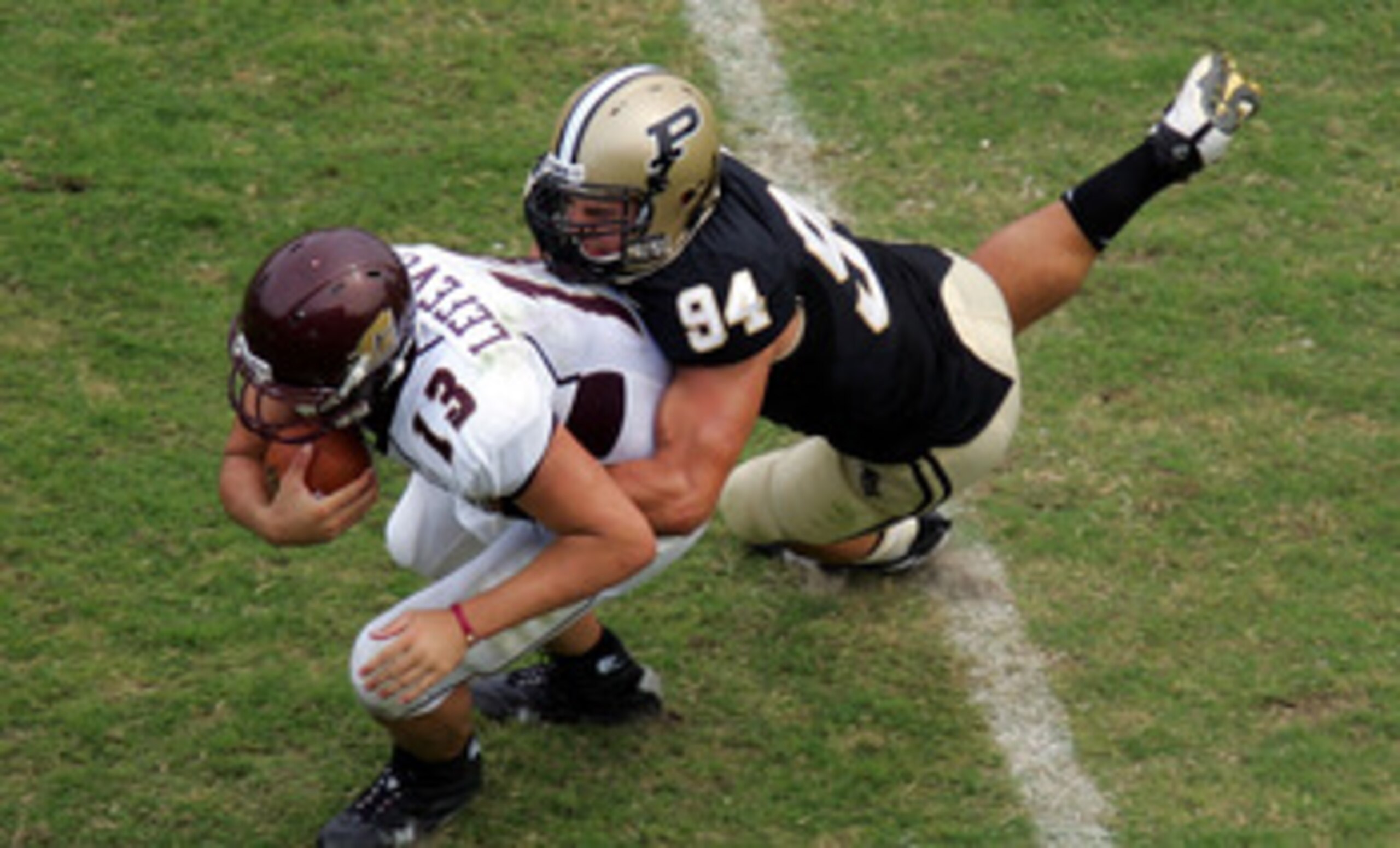 WEST LAFAYETTE, IN - SEPTEMBER 20:  Quarterback Dan LeFevour #13 of the Central Michigan Chippewas is tackled by Ryan Kerrigan #94 of the Purdue Boilermakers at Ross-Ade Stadium on September 20, 2008 in West Lafayette, Indiana.  (Photo by Ronald Martinez/