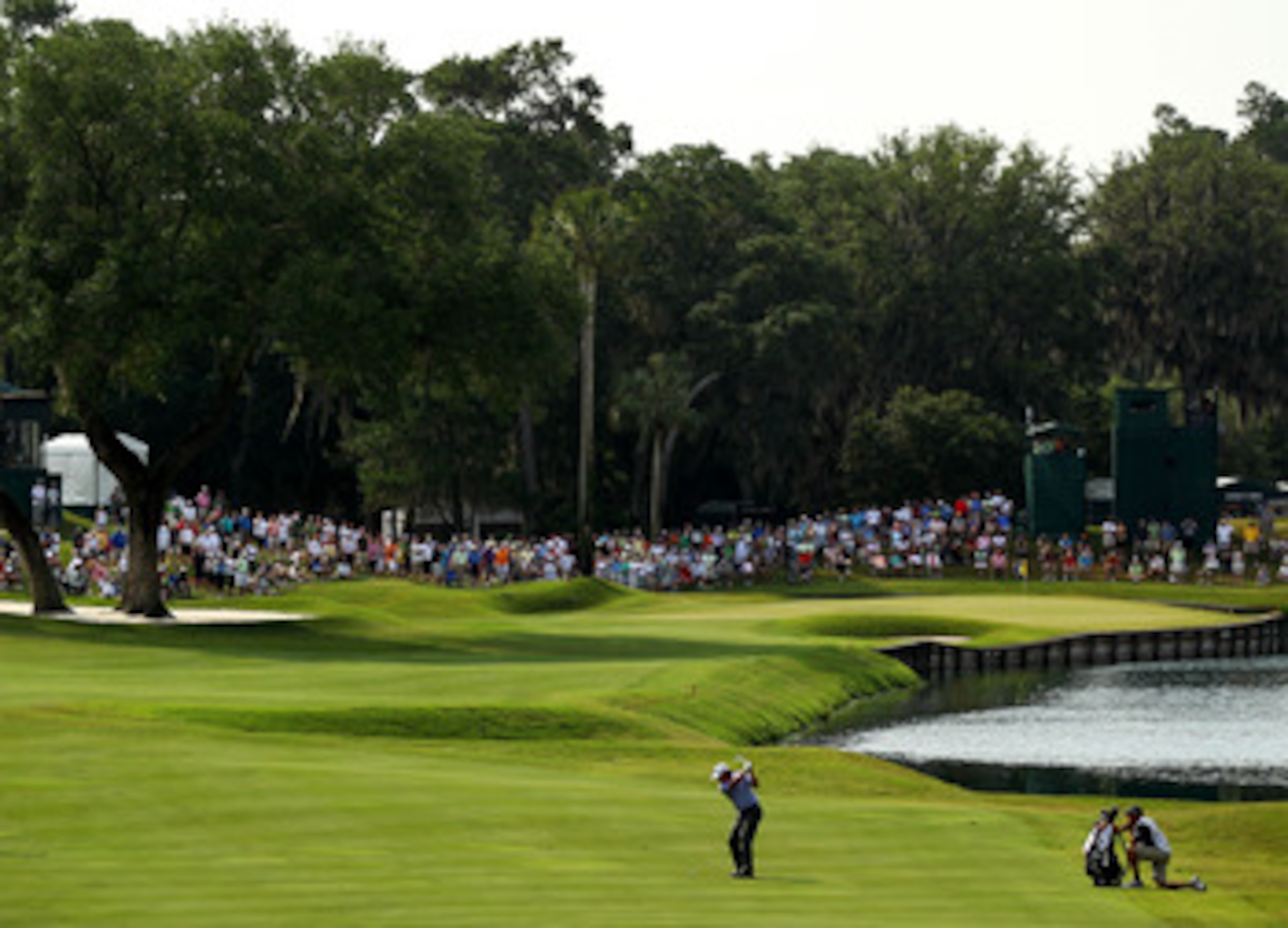 PONTE VEDRA BEACH, FL - MAY 13: Phil Mickelson hits a shot on the 16th hole as his caddie Jim Mackay looks on during the second round of THE PLAYERS Championship held at THE PLAYERS Stadium course at TPC Sawgrass on May 13, 2011 in Ponte Vedra Beach, Flo PONTE VEDRA BEACH, FL - MAY 13: Phil Mickelson hits a shot on the 16th hole as his caddie Jim Mackay looks on during the second round of THE PLAYERS Championship held at THE PLAYERS Stadium course at TPC Sawgrass on May 13, 2011 in Ponte Vedra Beach, Flo