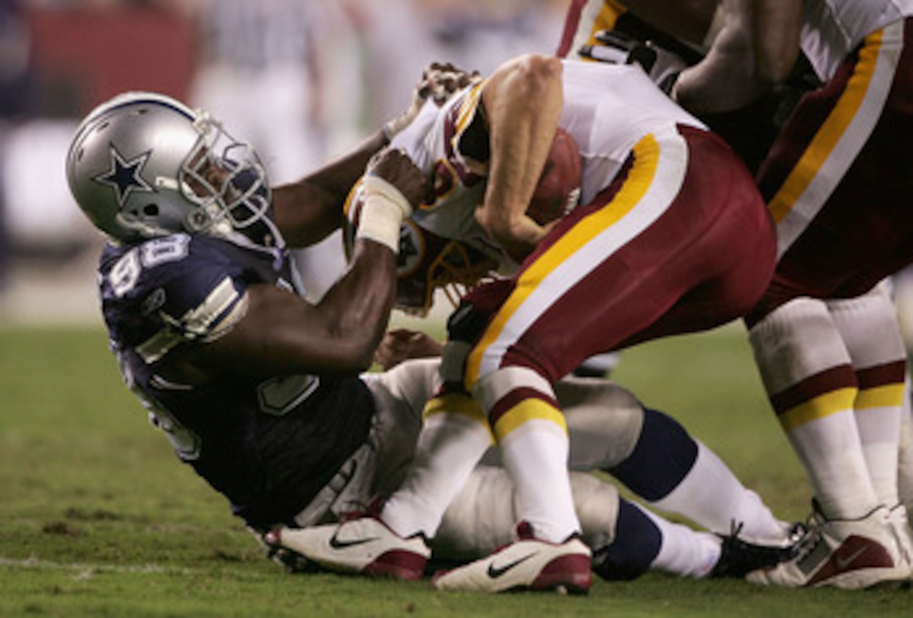 LANDOVER, MD - SEPTEMBER 27: La'Roi Glover #97 of the Dallas Cowboys sacks quarterback Mark Brunell #8 of the Washington Redskins during the second quarter of play during the third week of the NFL season at FedEx Field September 27, 2004 in Landover, Mary