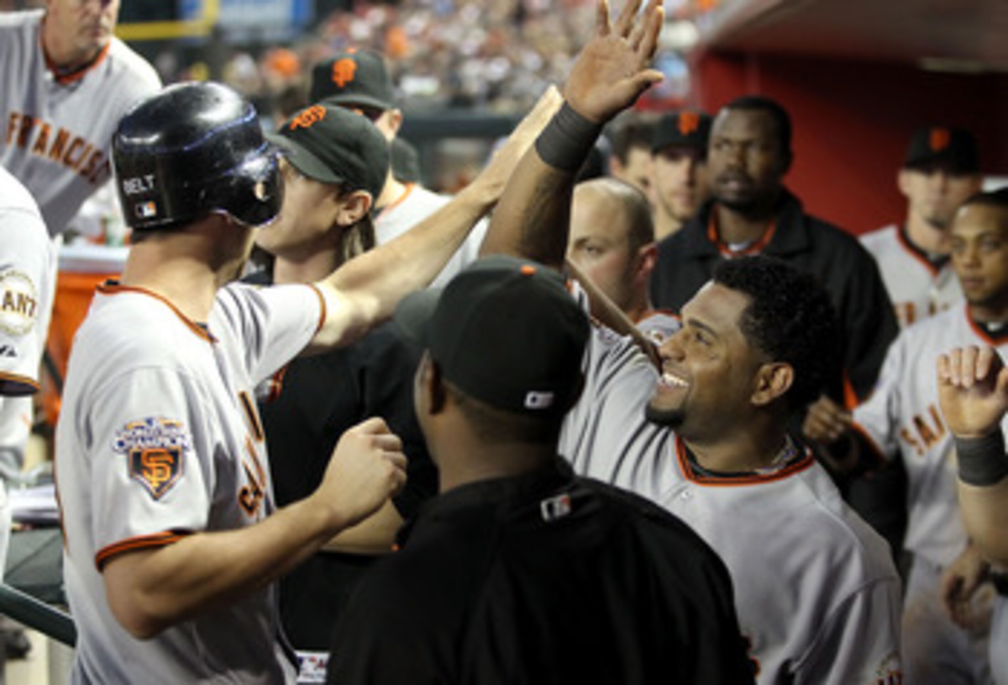 PHOENIX, AZ - APRIL 16:  Pablo Sandoval #48 of the San Francisco Giants high fives teammate Brandon Belt #9 after he scored a seventh inning run against the Arizona Diamondbacks during the Major League Baseball game at Chase Field on April 16, 2011 in Pho