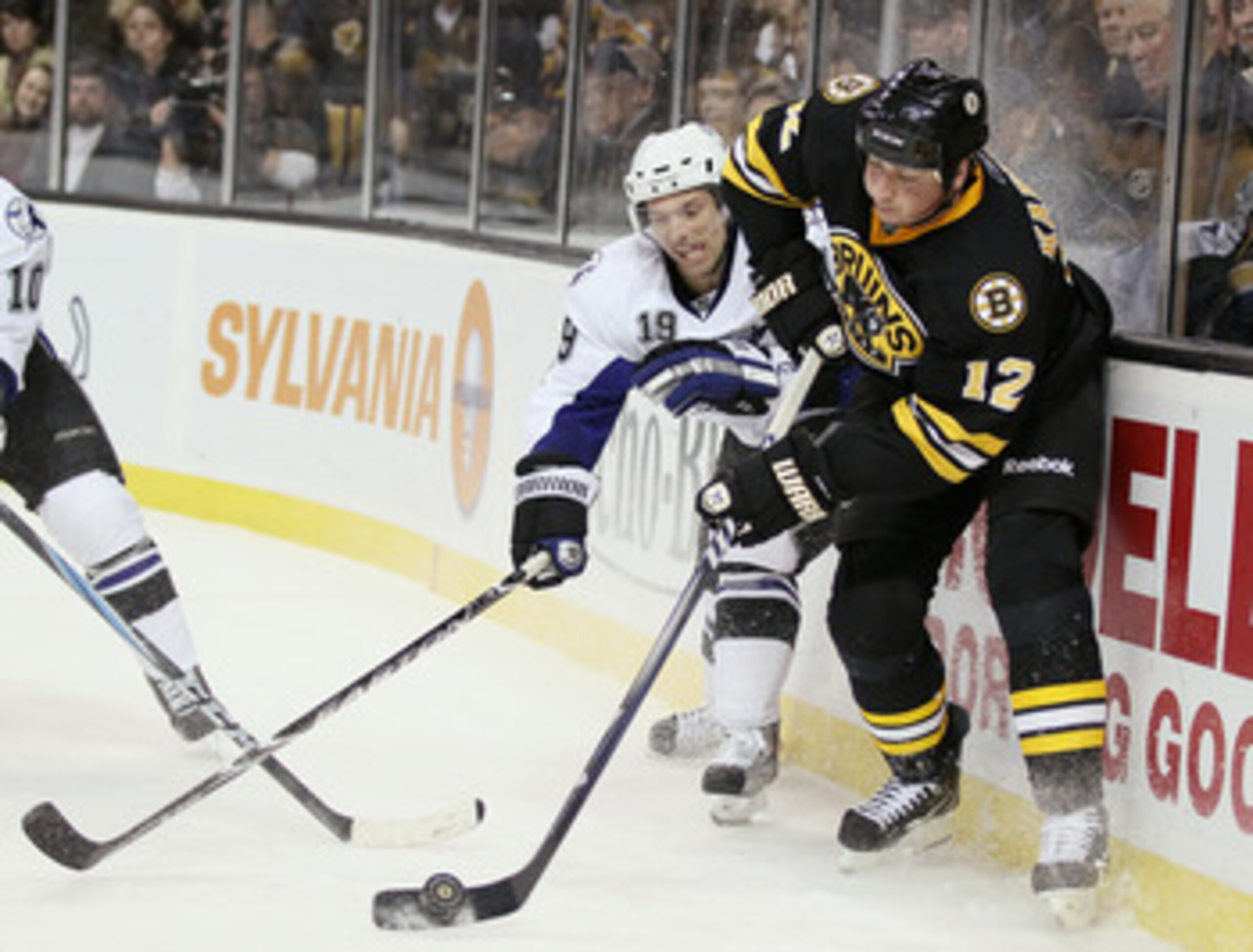 BOSTON, MA - MARCH 03:  Tomas Kaberle #12 of the Boston Bruins and Dominic Moore #19 of the Tampa Bay Lightning fight for the puck on March 3, 2011 at the TD Garden in Boston, Massachusetts.  (Photo by Elsa/Getty Images)