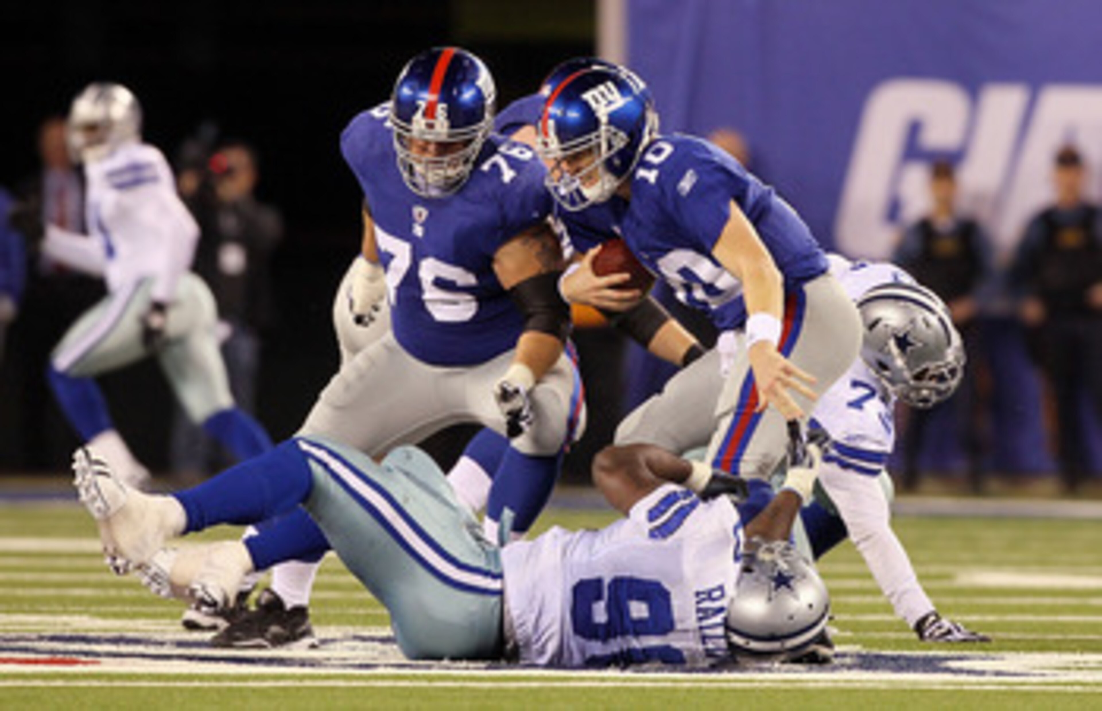 EAST RUTHERFORD, NJ - NOVEMBER 14:  Eli Manning #10 of the New York Giants scrambles to avoid a sack in the fourth quarter by Jay Ratliff #90 of the Dallas Cowboys on November 14, 2010 at the New Meadowlands Stadium in East Rutherford, New Jersey. The Cow