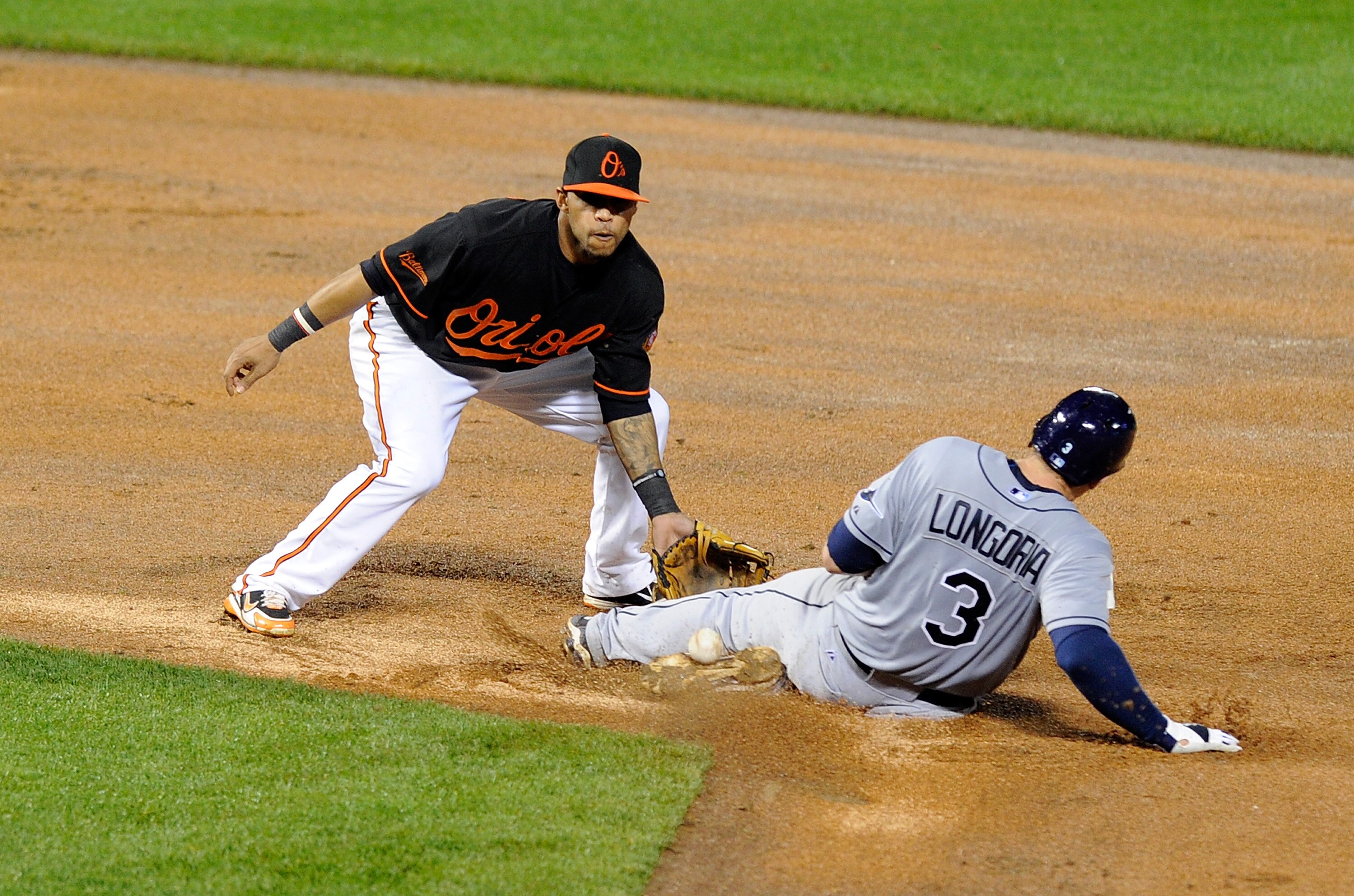 BALTIMORE, MD - MAY 06:  Evan Longoria #3 of the Tampa Bay Rays slides into second base ahead of the throw to Robert Andino #11 of the Baltimore Orioles at Oriole Park at Camden Yards on May 6, 2011 in Baltimore, Maryland.  (Photo by Greg Fiume/Getty Imag
