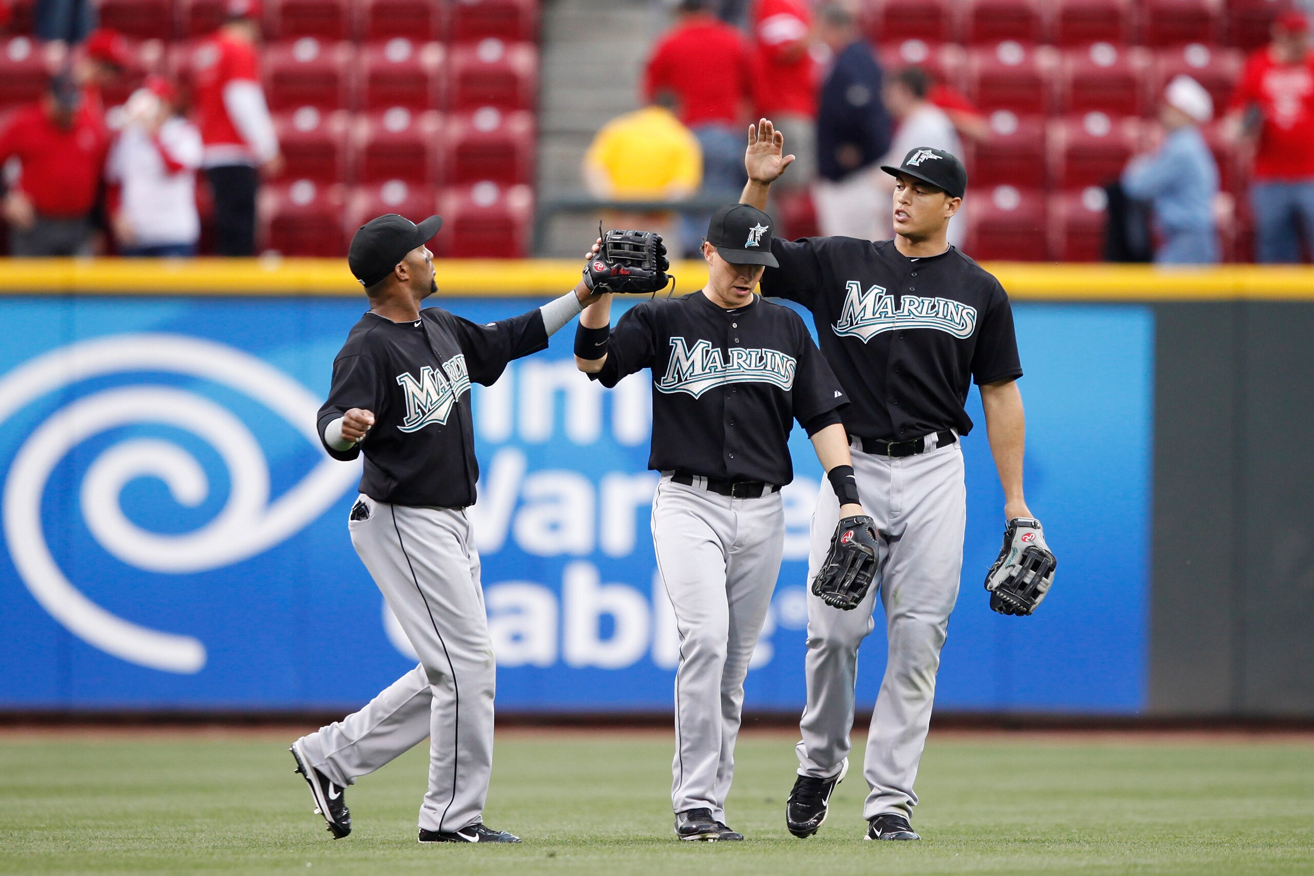 CINCINNATI, OH - MAY 1: Emilio Bonifacio #1, Chris Coghlan #8 and Mike Stanton #27 of the Florida Marlins celebrate after the final out against the Cincinnati Reds at Great American Ball Park on May 1, 2011 in Cincinnati, Ohio. The Marlins defeated the Re