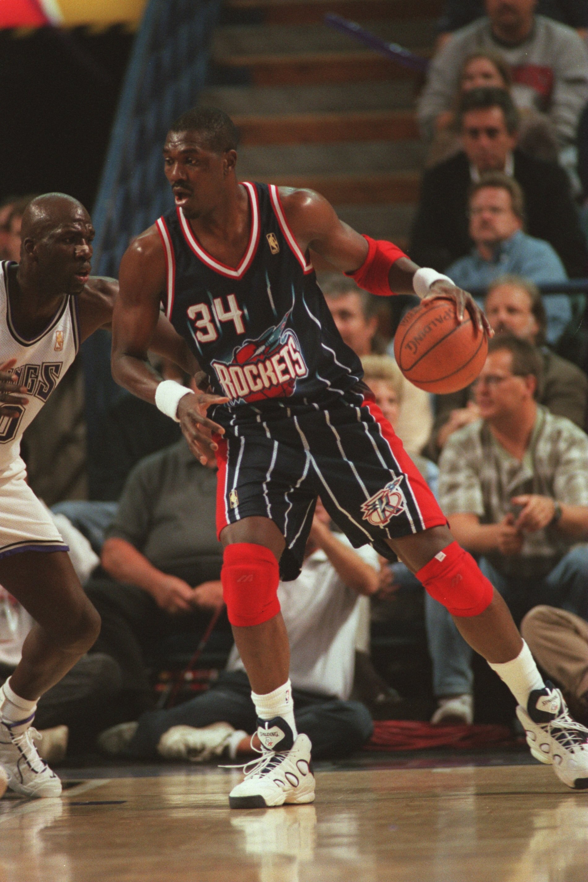 5 Nov 1996: Center Hakeem Olajuwon #34 of the Houston Rockets handles the basketball as he battles with Olden Polynice #0 of the Sacramento Kings for position during a play in the Rockets 102-80 victory over the Kings at Arco Arena in Sacramento, Californ