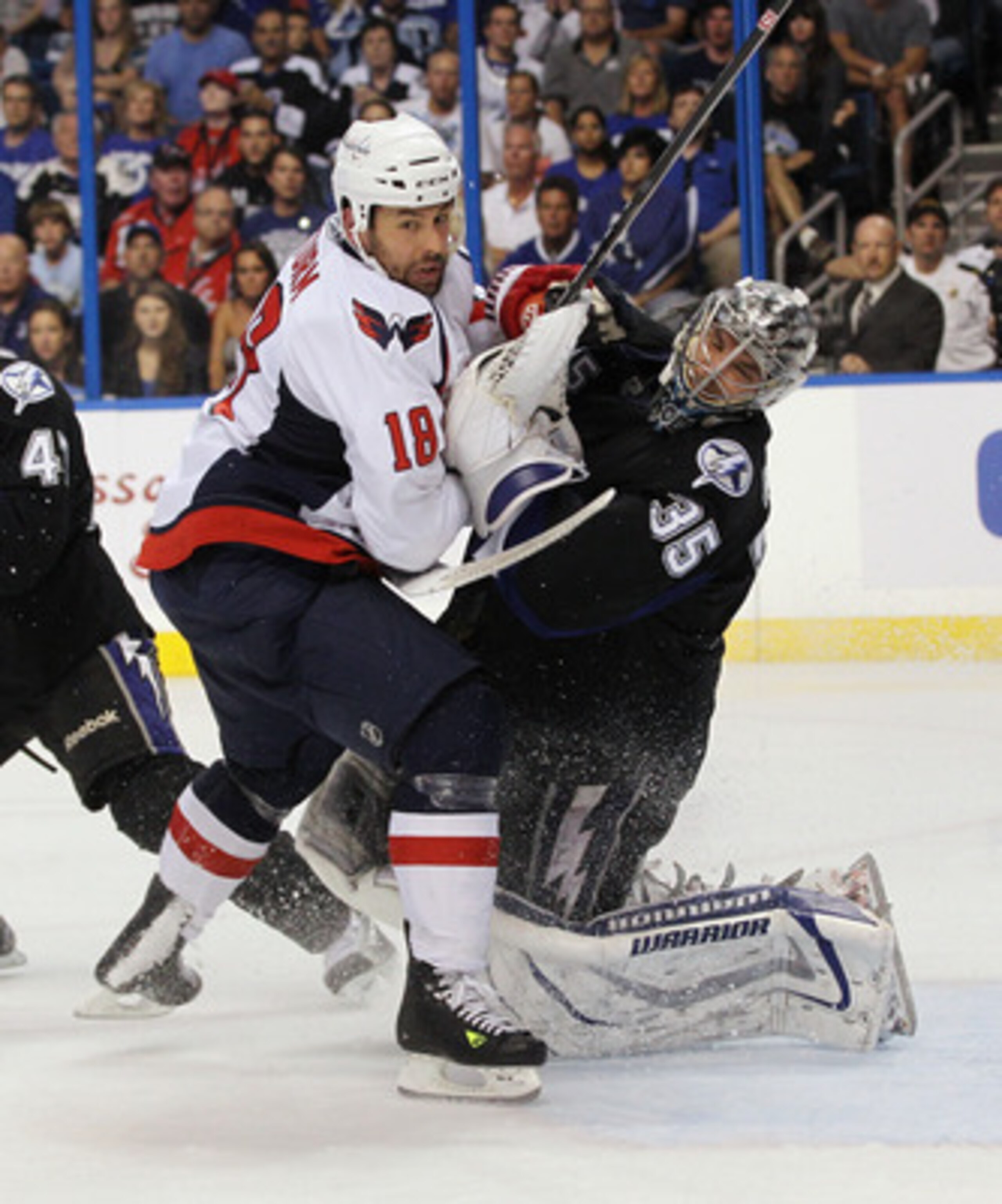 TAMPA, FL - MAY 04: Marco Sturm #18 of the Washington Capitals takes a goaltender interference penalty against Dwayne Roloson #35 of the Tampa Bay Lightning in Game Four of the Eastern Conference Semifinals during the 2011 NHL Stanley Cup Playoffs at the 