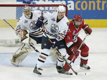 RALEIGH, NC - JUNE 5:  Chris Pronger #44 of the Edmonton Oilers vies for slot position with Justin Williams #11 of the Carolina Hurricanes as goaltender Dwayne Roloson #35 of the Edmonton Oilers tries to get a look at the play during game one of the 2006 