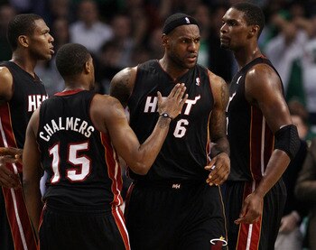 BOSTON, MA - MAY 09: LeBron James #6 of the Miami Heat is congratulated by teammates Chris Bosh  #1 and Mario Chalmers #15 after James drew the foul in the second half against the Boston Celtics in Game Four of the Eastern Conference Semifinals in the 201