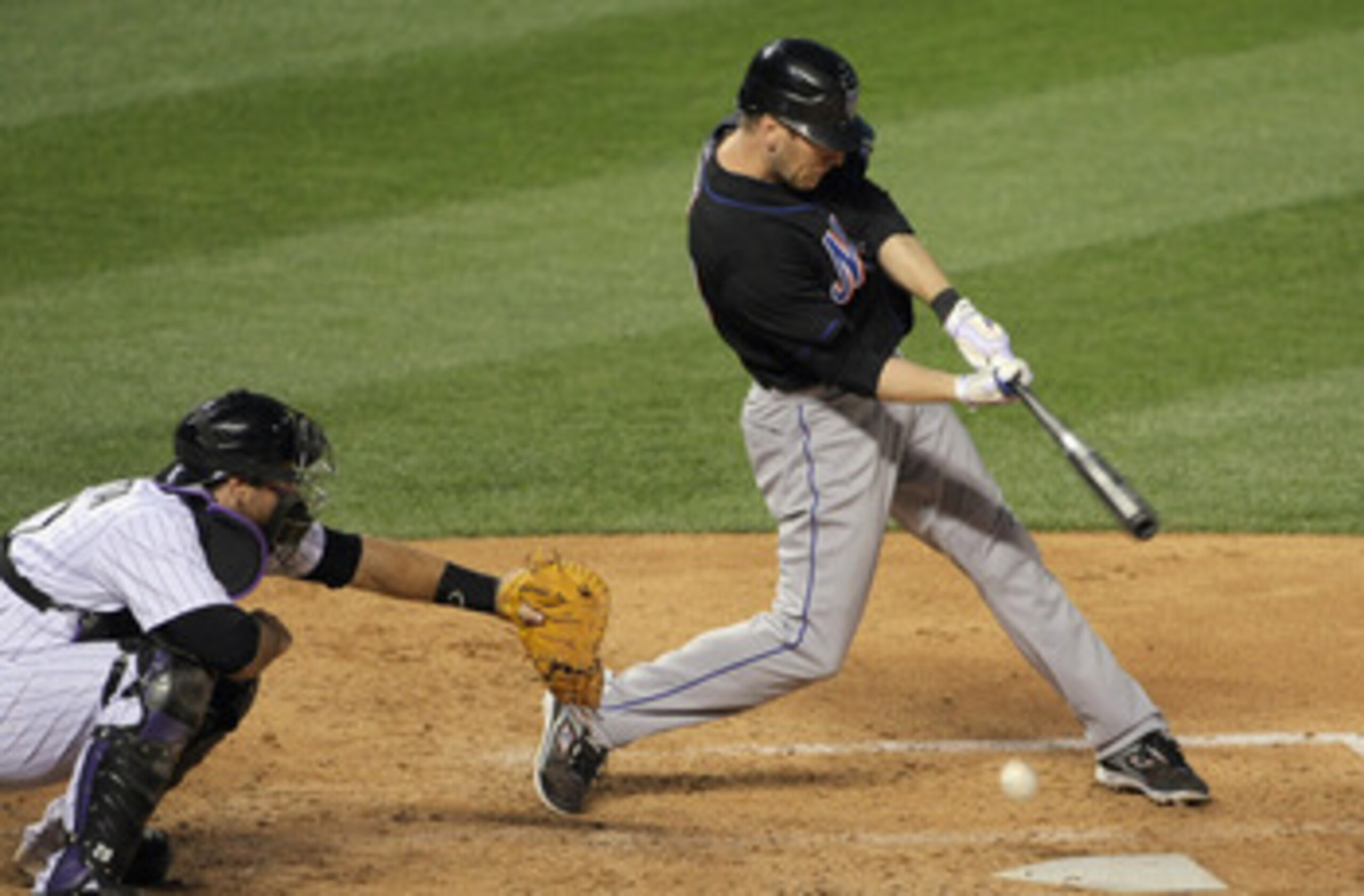 DENVER, CO - MAY 09:  Jason Bay #44 of the New York Mets hits a soft grounder as catcher Chris Iannetta #20 of the Colorado Rockies backs up the plate as Bay was safe at first on a throwing error by third baseman Ian Stewart #9 of the Colorado Rockies as