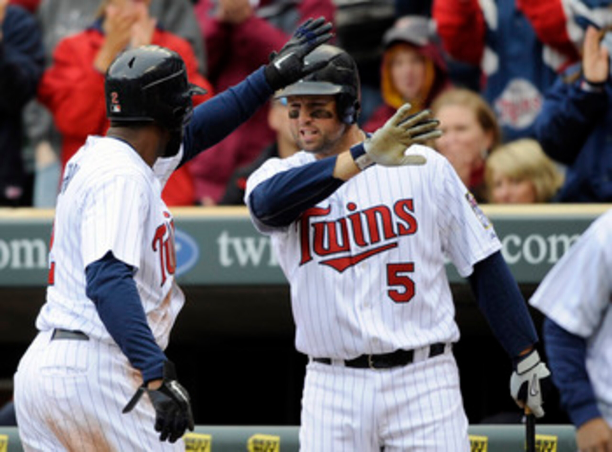 MINNEAPOLIS, MN - APRIL 23: Denard Span #2 and Michael Cuddyer #5 of the Minnesota Twins celebrate teammate Jason Repko #18 scoring against the Cleveland Indians during the third inning of their game on April 23, 2011 at Target Field in Minneapolis, Minne
