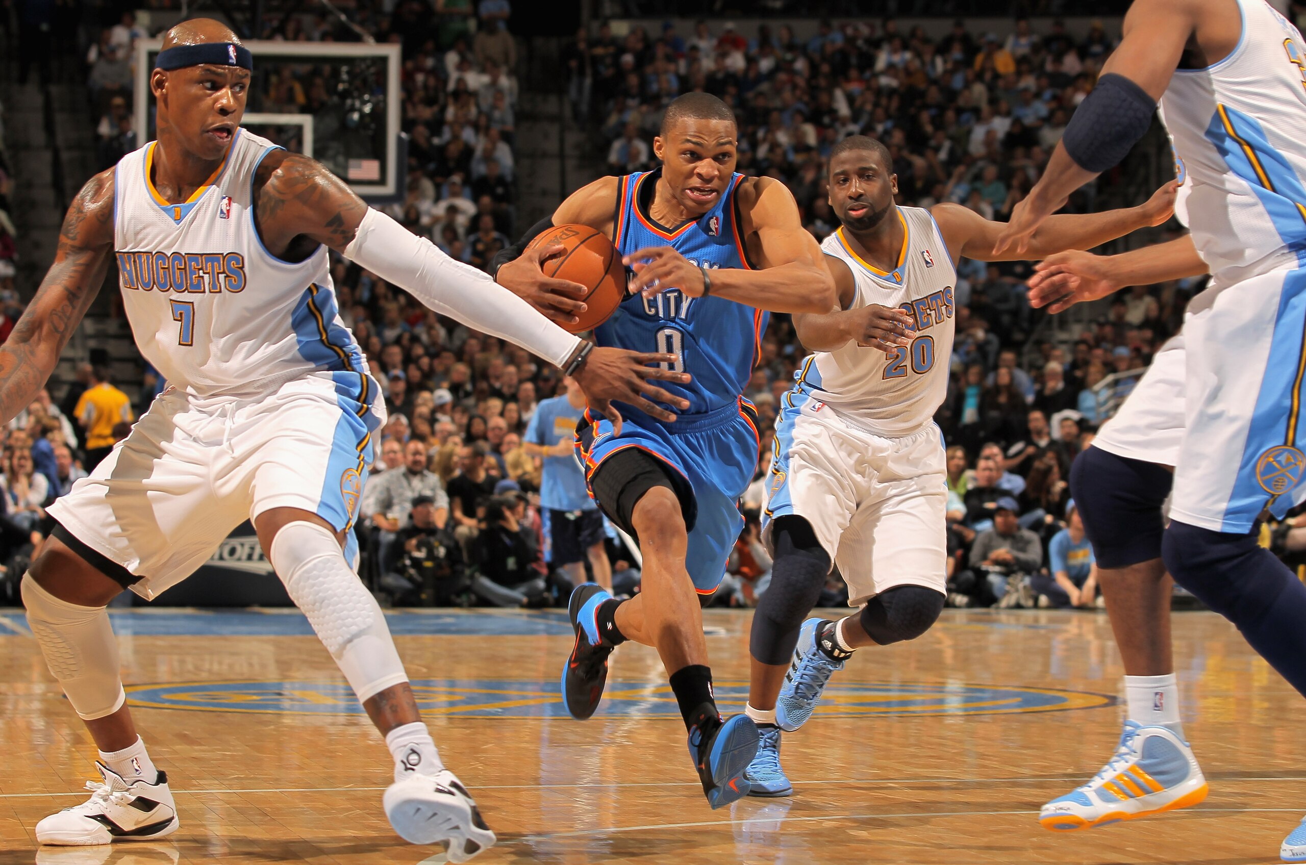 DENVER, CO - APRIL 23:  Russell Westbrook #0 of the Oklahoma City Thunder drives to the basket between Al Harrington #7 and Raymond Felton #20 of the Denver Nuggets in Game Three of the Western Conference Quarterfinals in the 2011 NBA Playoffs on April 23
