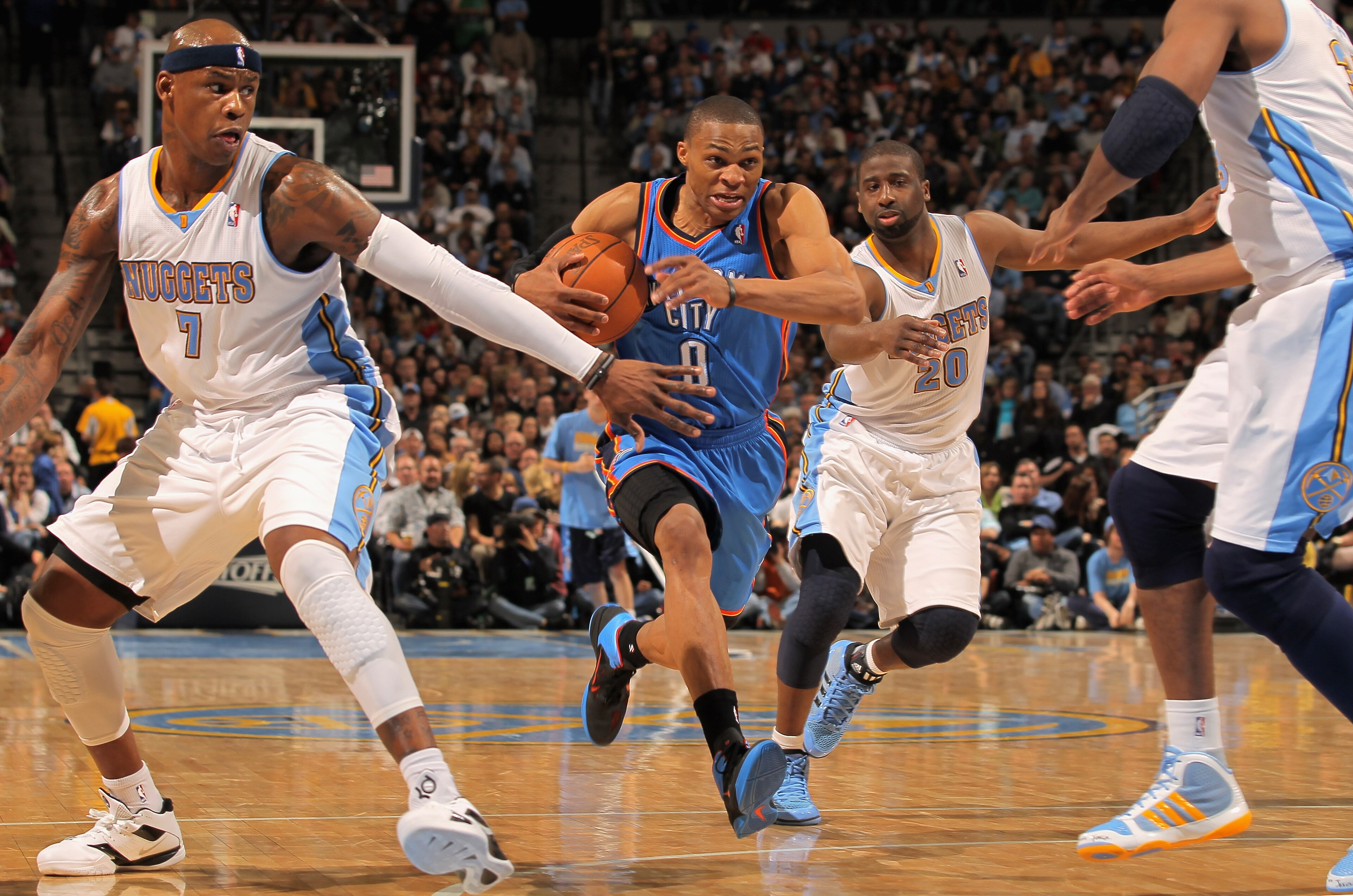 DENVER, CO - APRIL 23:  Russell Westbrook #0 of the Oklahoma City Thunder drives to the basket between Al Harrington #7 and Raymond Felton #20 of the Denver Nuggets in Game Three of the Western Conference Quarterfinals in the 2011 NBA Playoffs on April 23
