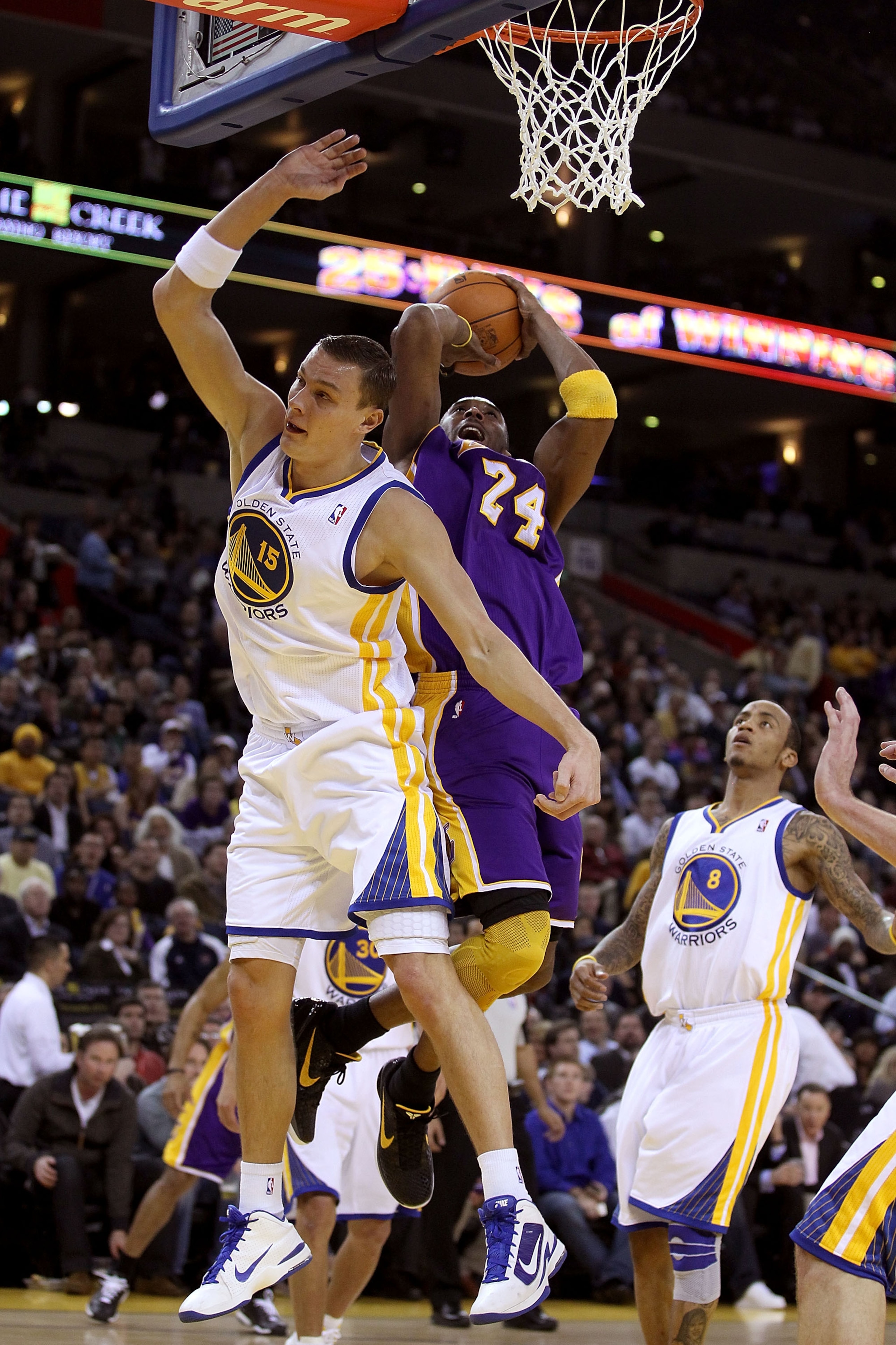 OAKLAND, CA - JANUARY 12: Kobe Bryant #24 of the Los Angeles Lakers is fouled by Andris Biedrins #15 of the Golden State Warriors at Oracle Arena on January 12, 2011 in Oakland, California. NOTE TO USER: User expressly acknowledges and agrees that, by dow