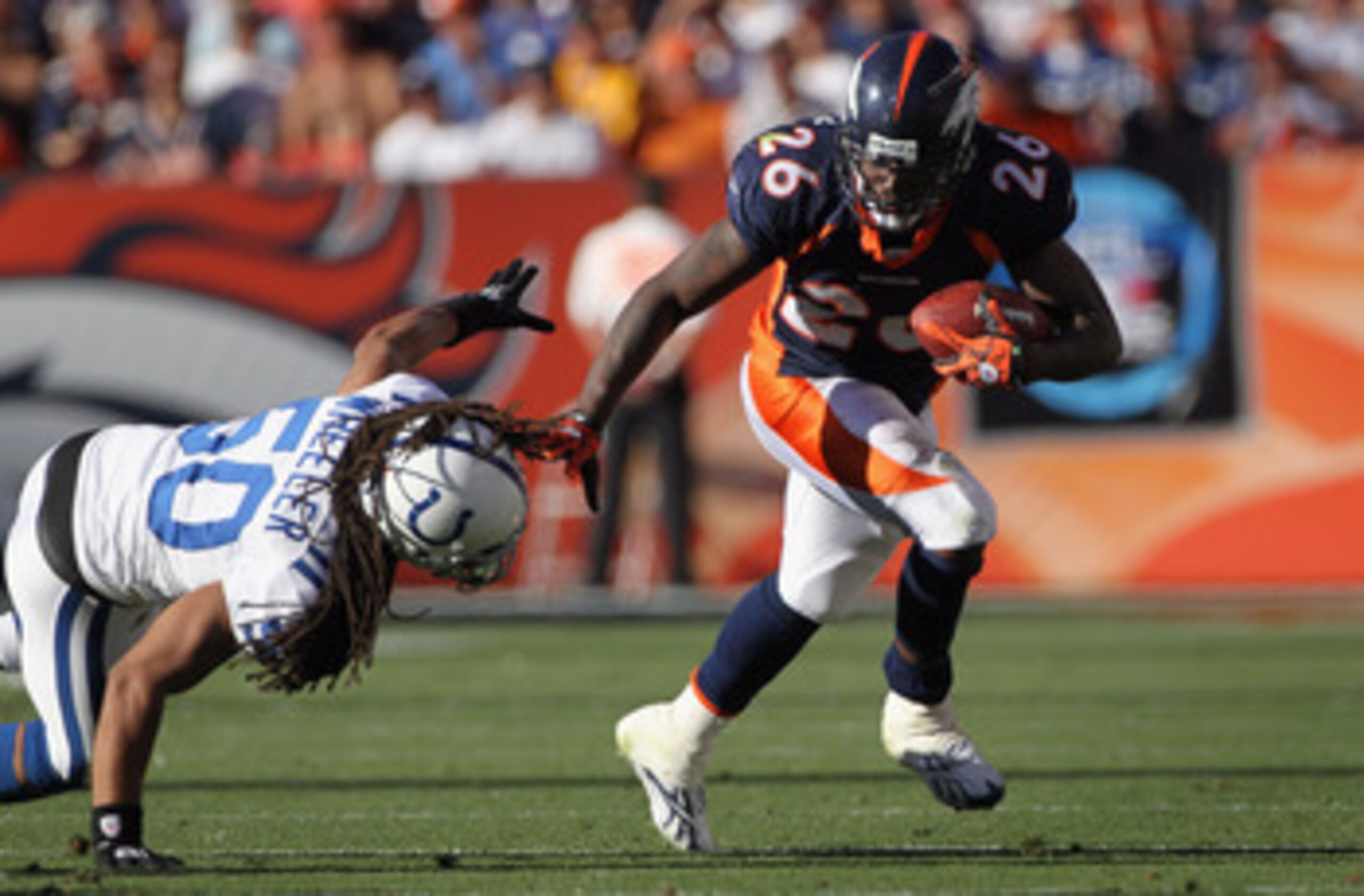 DENVER - SEPTEMBER 26:  Running back Laurence Maroney #26 of the Denver Broncos eludes Philip Wheeler #50 of the Indianapolis Colts to pick up 26 yards and a first down on a screen pass at INVESCO Field at Mile High on September 26, 2010 in Denver, Colora
