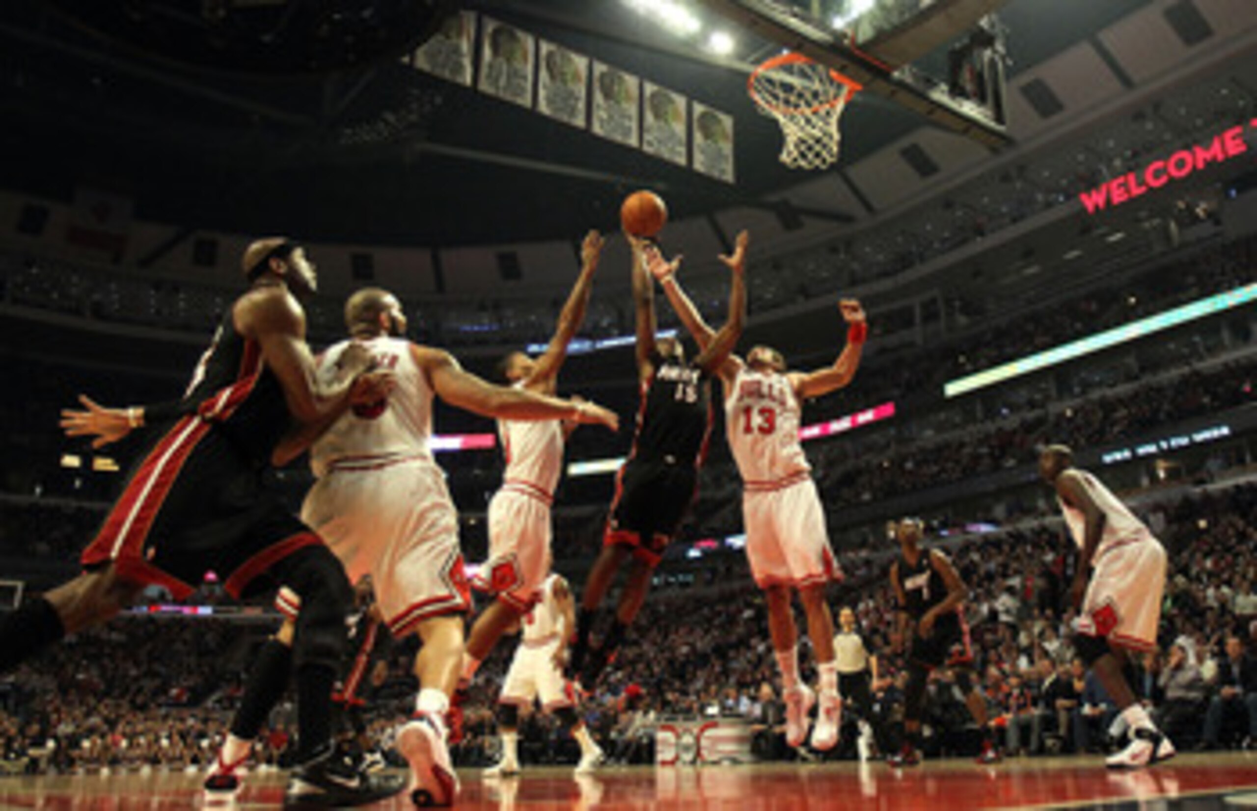 CHICAGO, IL - FEBRUARY 24: Mario Chalmers #15 of the Miami Heat puts up a shot between Derrick Rose #1 and Joakim Noah #13 of the Chicago Bulls at the United Center on February 24, 2011 in Chicago, Illinois. The Bulls defeated the Heat 93-89. NOTE TO USER