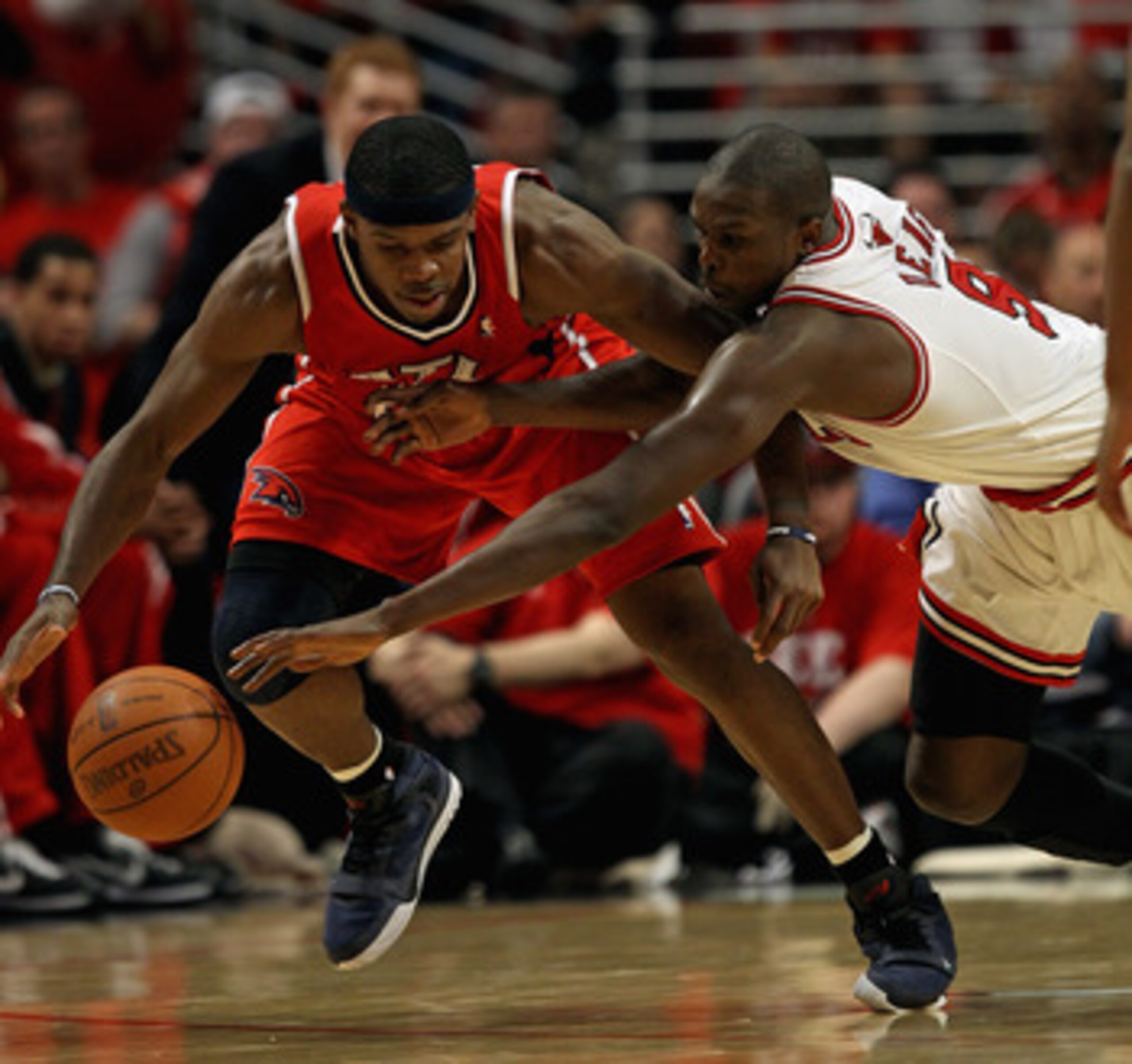 CHICAGO, IL - MAY 10: Loul Deng #9 of the Chicago Bulls dives for the ball held by Joe Johnson #2 of the Atlanta Hawks in Game Five of the Eastern Conference Semifinals in the 2011 NBA Playoffs at the United Center on May 10, 2011 in Chicago, Illinois. Th