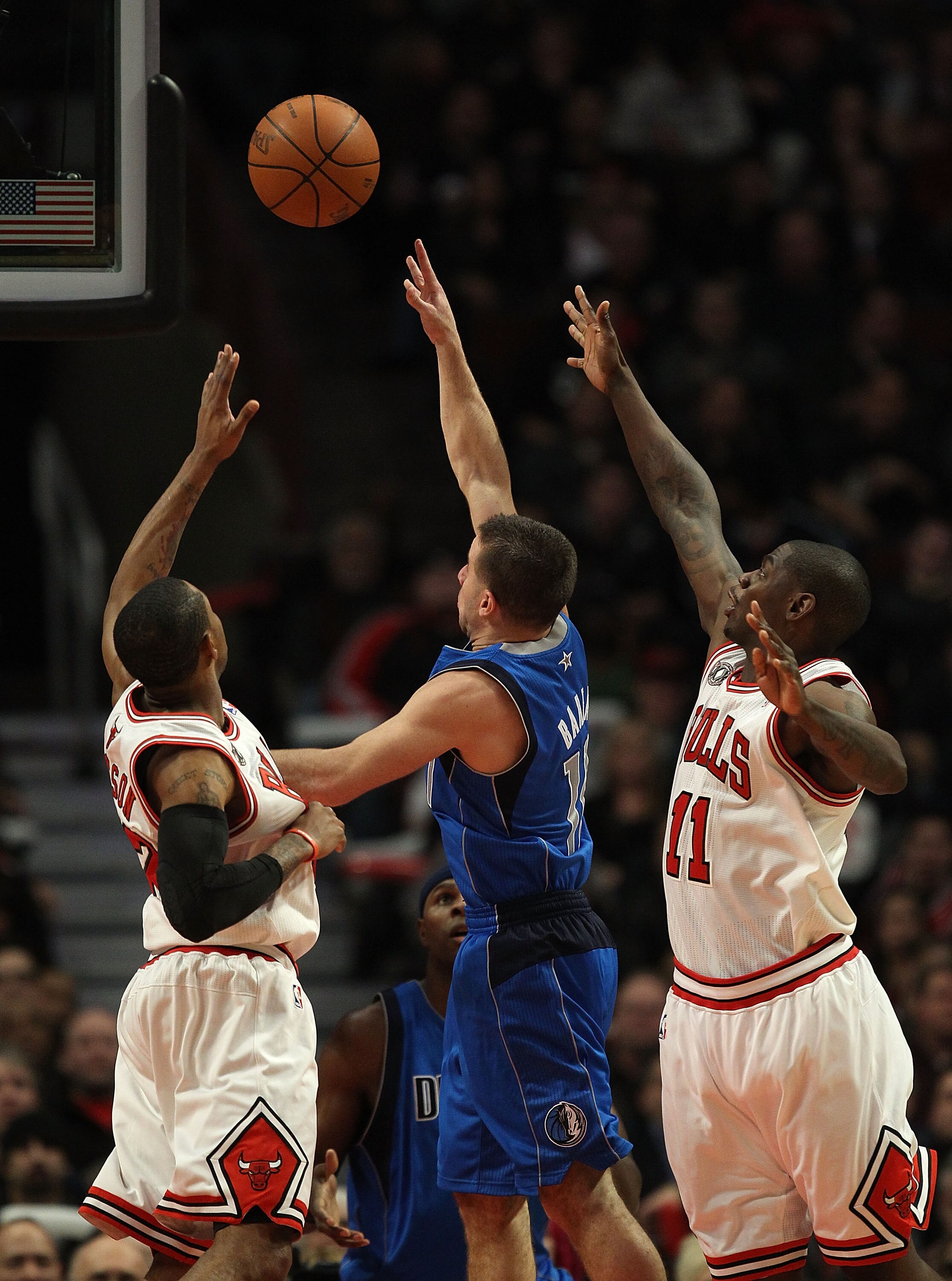 CHICAGO, IL - JANUARY 20: Jose Barera #11 of the Dallas Mavericks goes up for a shot between C.J. Watson #32 and Ronnie Brewer #11 of the Chicago Bulls at the United Center on January 20, 2011 in Chicago, Illinois. The Bulls defeated the Mavericks 82-77.