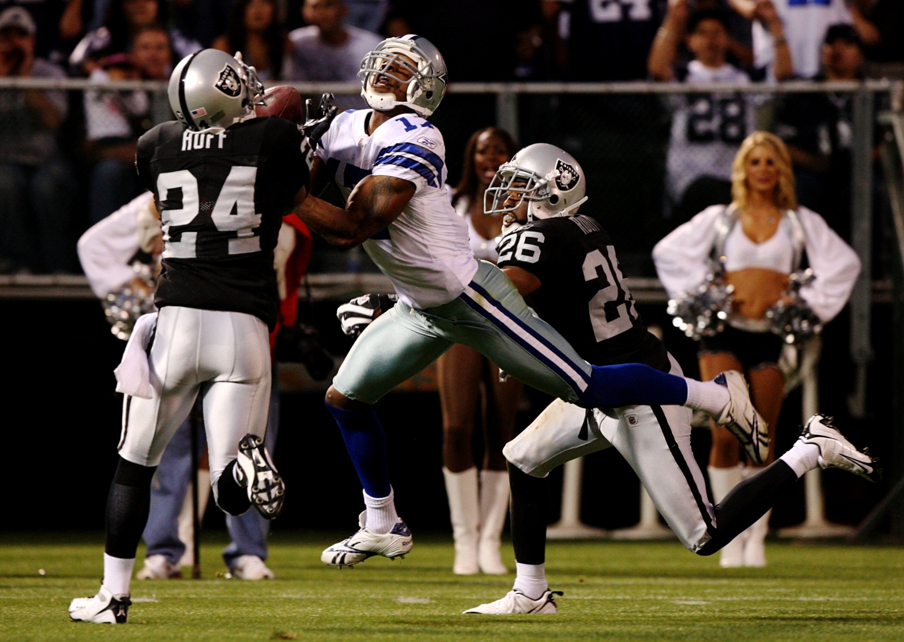 OAKLAND, CA - AUGUST 13: Safety Michael Huff #24 of the Oakland Raiders intercepts the ball over Sam Hurd #17 of the Dallas Cowboys during the preseason game at Oakland-Alameda County Coliseum on August 13, 2009 in Oakland, California. (Photo by Jed Jacob