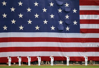 BOSTON, MA - MAY 02:  A giant flag covers the Green Monster as the national anthem is played before the game between the Boston Red Sox and the Los Angeles Angels on May 2, 2011 at Fenway Park in Boston, Massachusetts.  Both teams lined up on the baseline