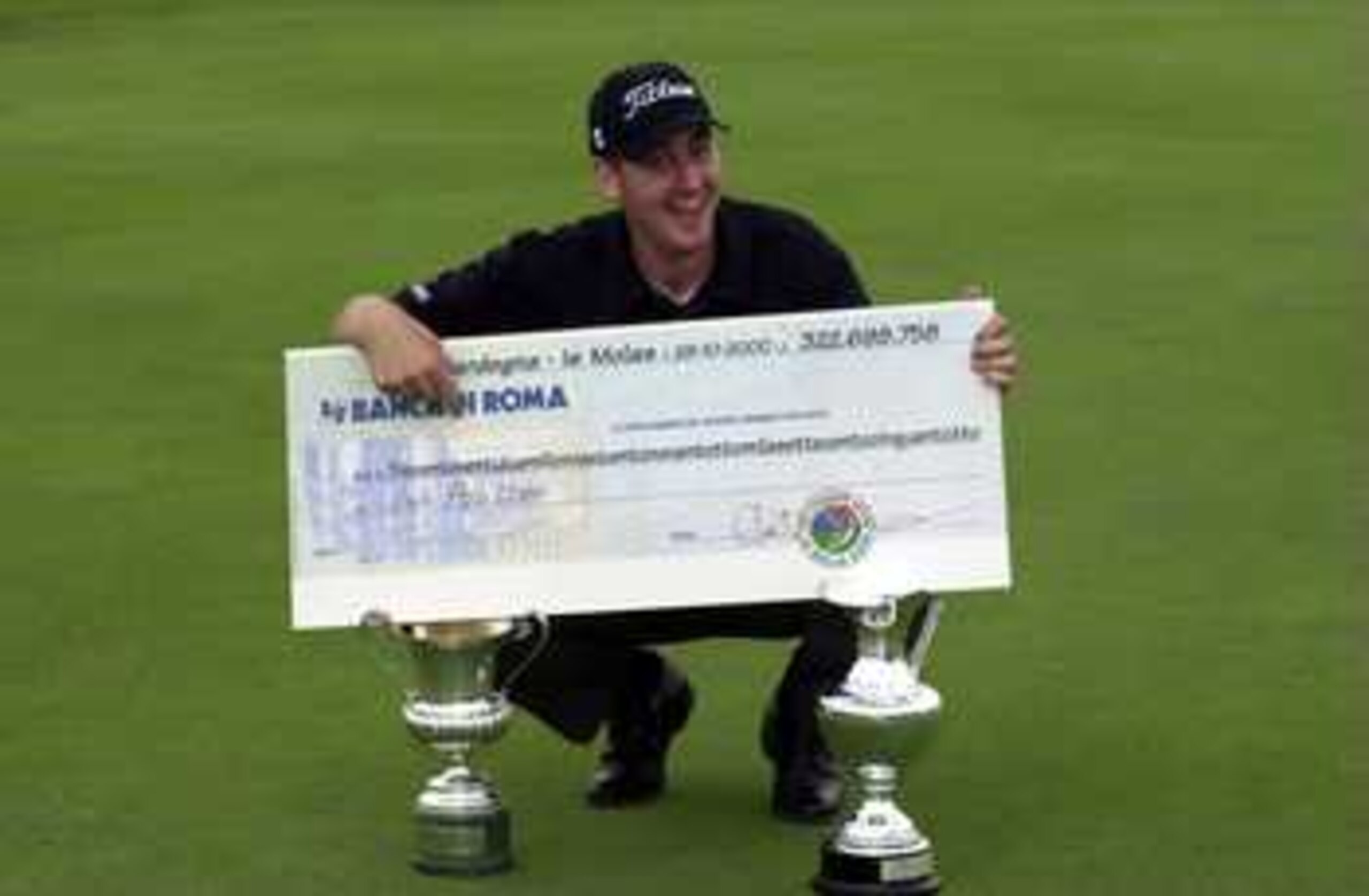 29 Oct 2000: Ian Poulter of England celebrates as a Lira millionaire with the cheque and the trophys after his first PGA European Tour win a one shot victory in the final round of the Italian Open at Is Molas Golf Course, Sardinia, Italy. Mandatory Credi 29 Oct 2000: Ian Poulter of England celebrates as a Lira millionaire with the cheque and the trophys after his first PGA European Tour win a one shot victory in the final round of the Italian Open at Is Molas Golf Course, Sardinia, Italy. Mandatory Credi