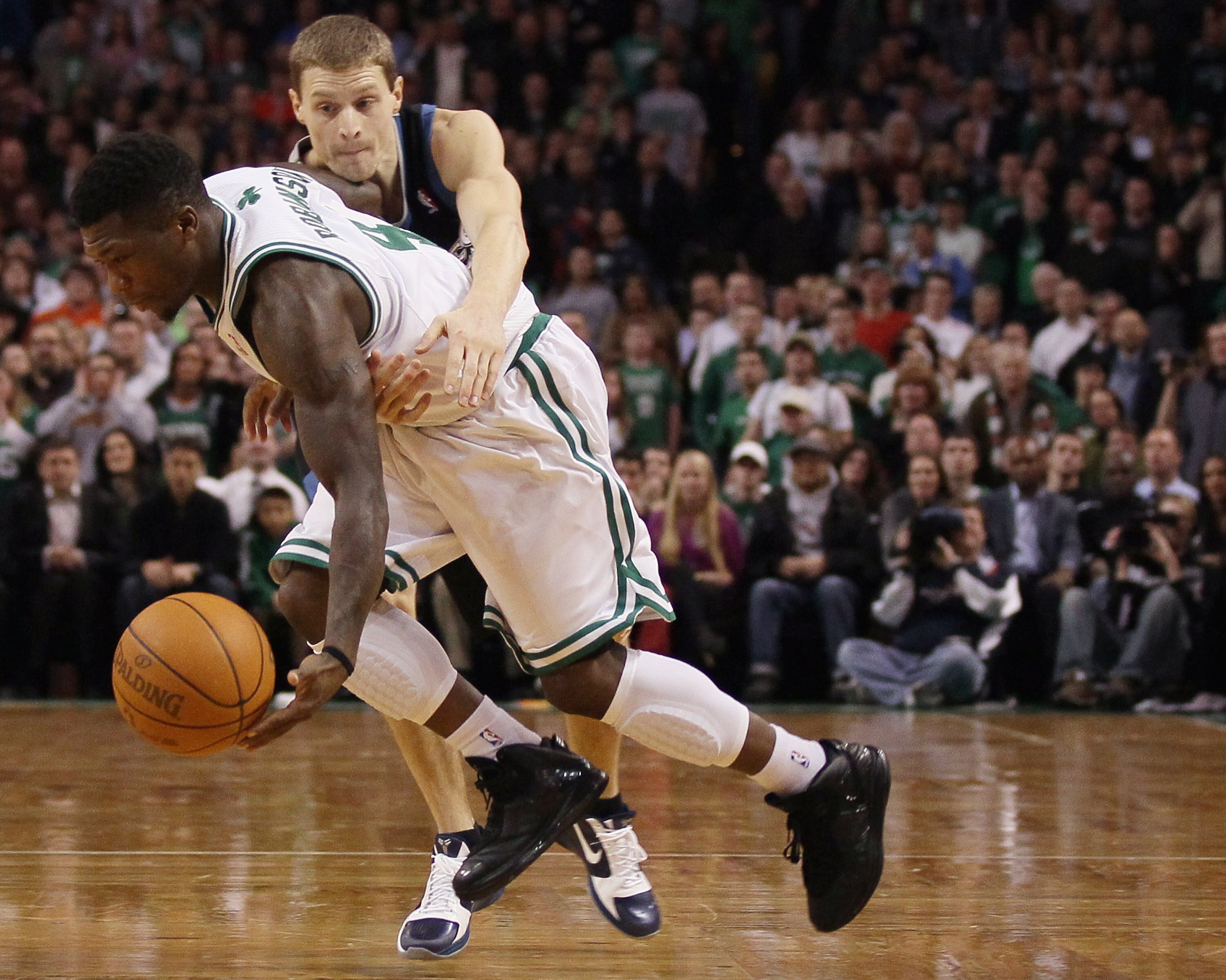 BOSTON, MA - JANUARY 03:  Nate Robinson #4 of the Boston Celtics tries to avoid the intentional foul by Luke Ridnour #13 of the Minnesota Timberwolves in the final minute of the game on January 3, 2011 at the TD Garden in Boston, Massachusetts. The Celtic
