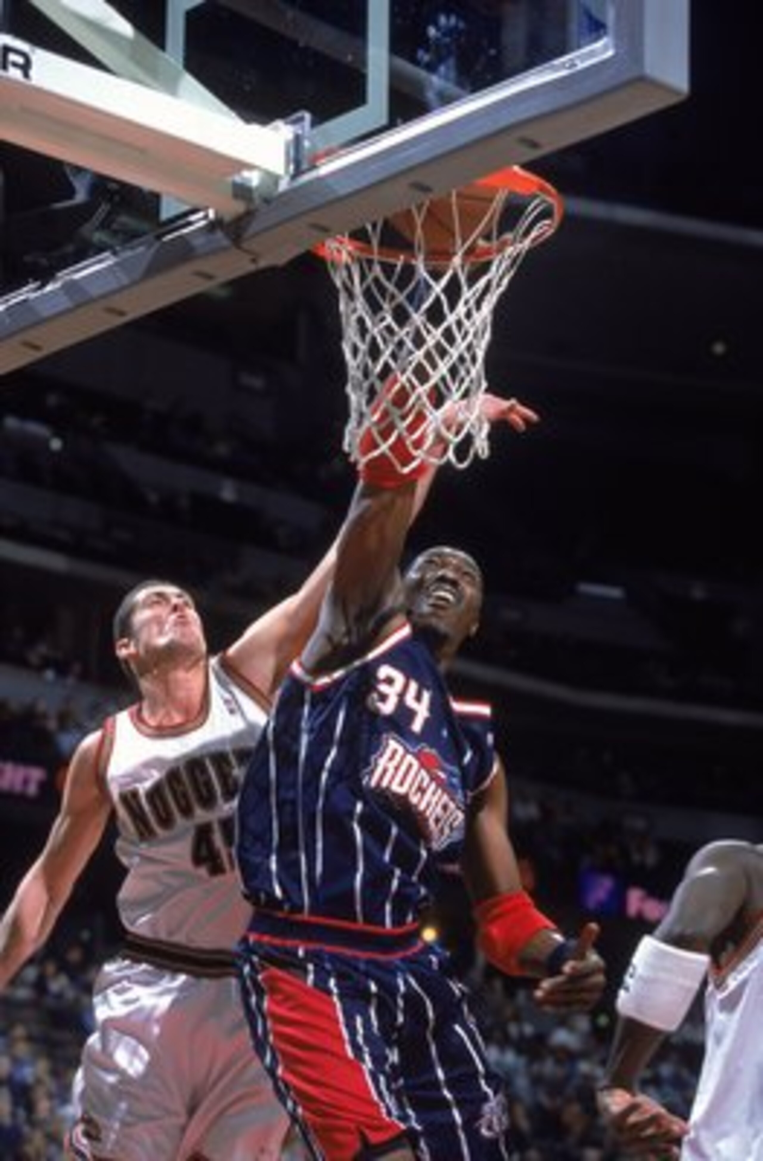 30 Nov 2000:  Hakeem Olajuwon #34 of the Houston Rockets dunks the ball against Raef LaFrantz #45 of the Denver Nuggets during the game at the Pepsi Center in Denver, Colorado.  The Nuggets defeated the Rockets 109-105.  NOTE TO USER: It is expressly unde