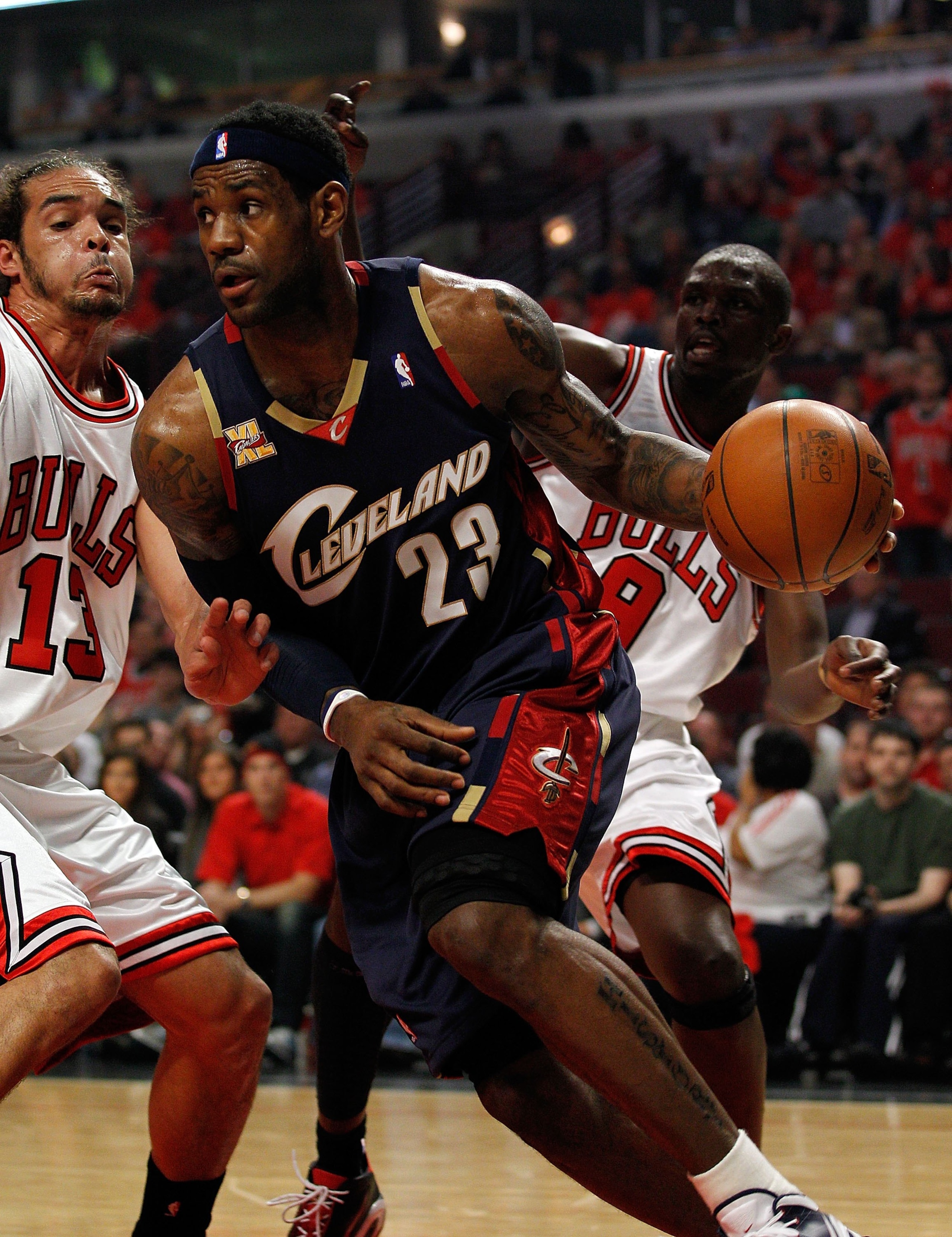 CHICAGO - APRIL 22: LeBron James #23 of the Cleveland Cavaliers drives around Joakim Noah #13 and Luol Deng #9 of the Chicago Bulls in Game Three of the Eastern Conference Quarterfinals during the 2010 NBA Playoffs at the United Center on April 22, 2010 i
