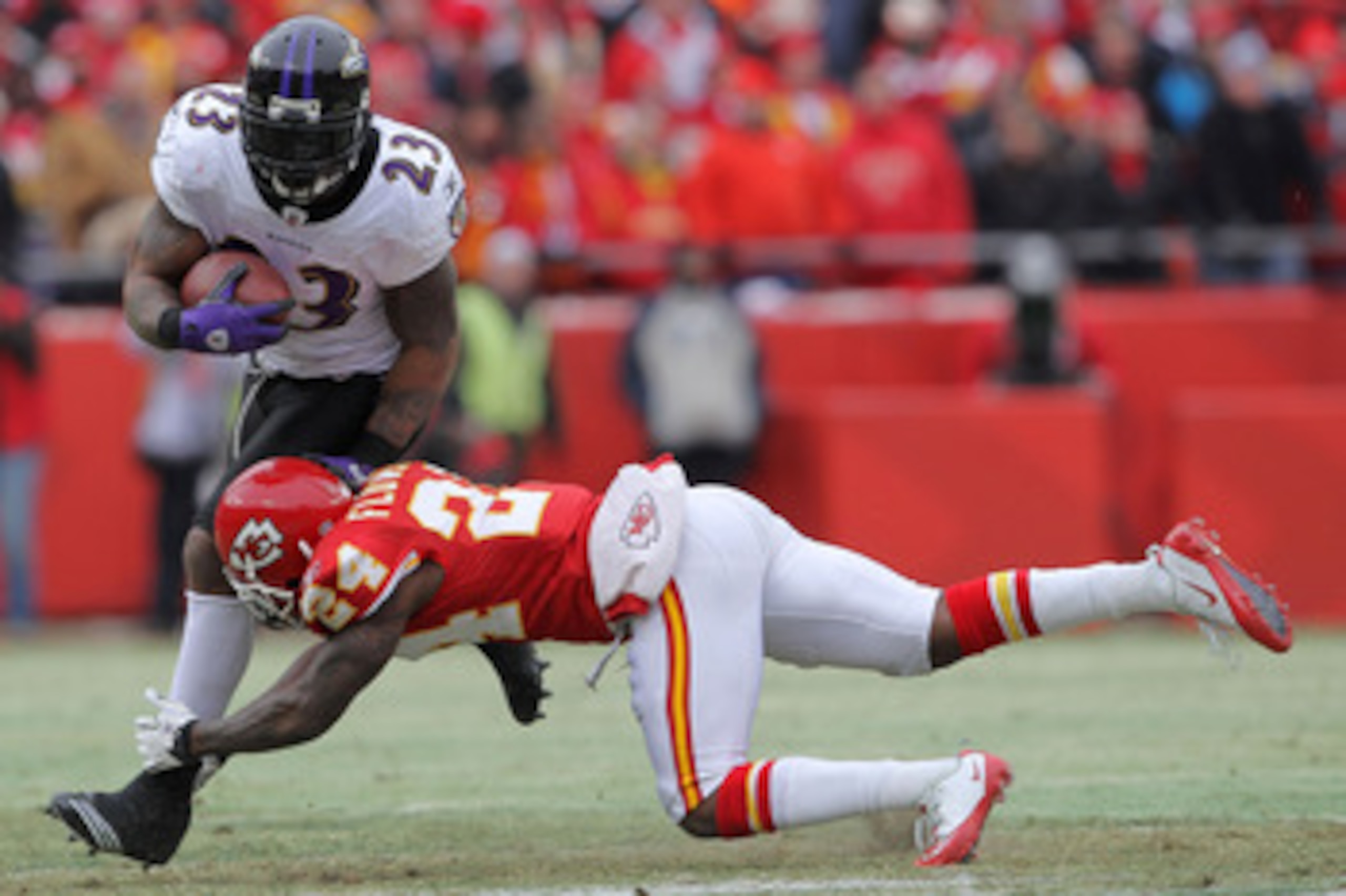 KANSAS CITY, MO - JANUARY 09:  Running back Willis McGahee #23 of the Baltimore Ravens breaks a tackle by cornerback Brandon Flowers #24 of the Kansas City Chiefs in the first half of their 2011 AFC wild card playoff game at Arrowhead Stadium on January 9