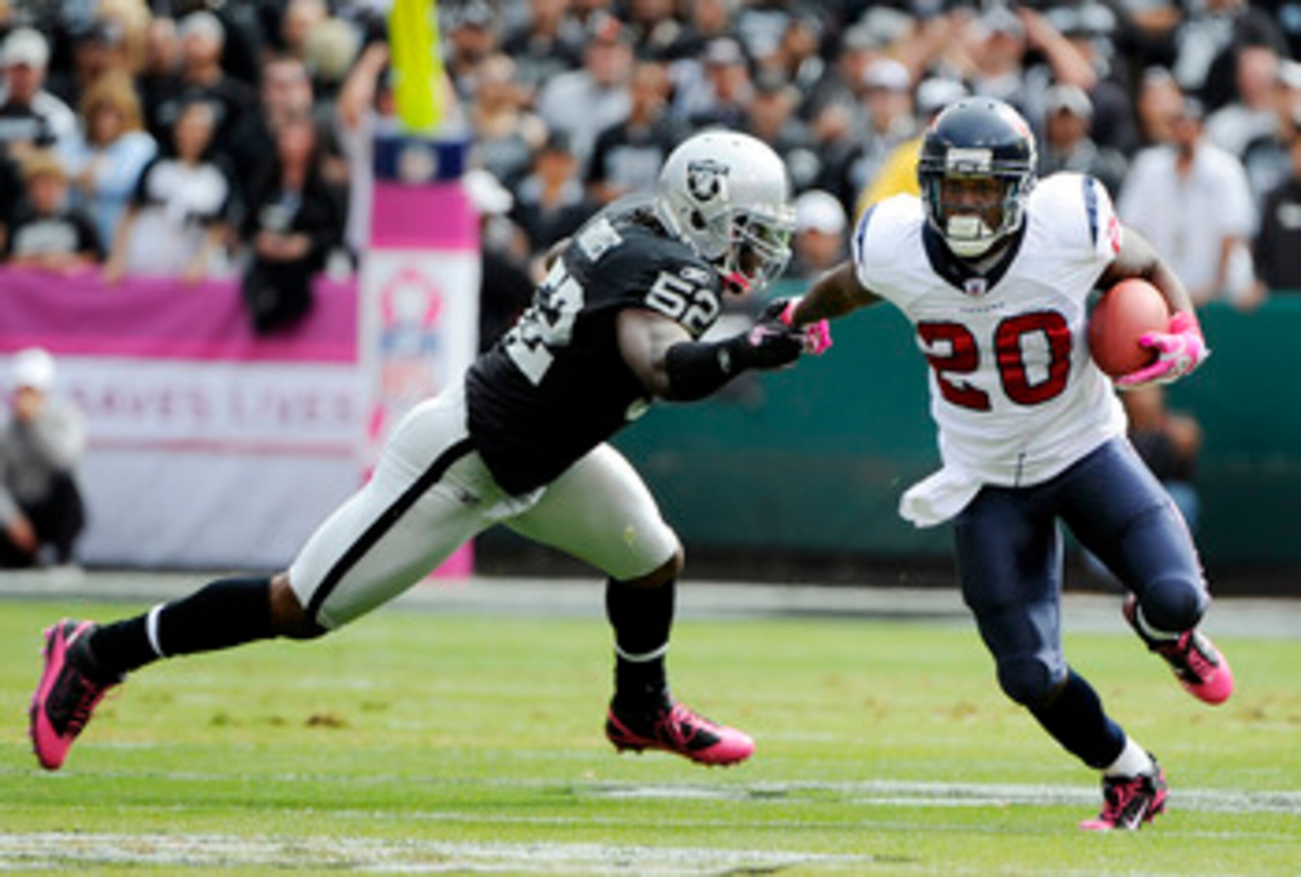 OAKLAND, CA - OCTOBER 3: Running back Steve Slaton #20 of the Houston Texans pushes away from linebacker Quentin Groves #52 of the Oakland Raiders during an NFL football game October 3, 2010 at The Oakland-Alameda County Coliseum in Oakland, California.  