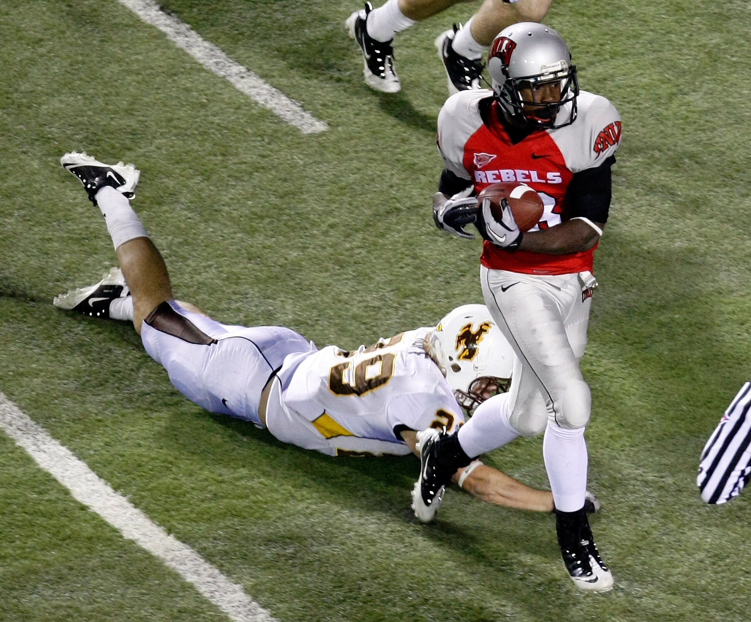 LAS VEGAS - NOVEMBER 13: Marcus Sullivan #18 of the UNLV Rebels catches a 41-yard touchdown pass in front of Luke Ruff #29 of the Wyoming Cowboys during their game at Sam Boyd Stadium November 13, 2010 in Las Vegas, Nevada. UNLV won 42-16. (Photo by Eth LAS VEGAS - NOVEMBER 13: Marcus Sullivan #18 of the UNLV Rebels catches a 41-yard touchdown pass in front of Luke Ruff #29 of the Wyoming Cowboys during their game at Sam Boyd Stadium November 13, 2010 in Las Vegas, Nevada. UNLV won 42-16. (Photo by Eth
