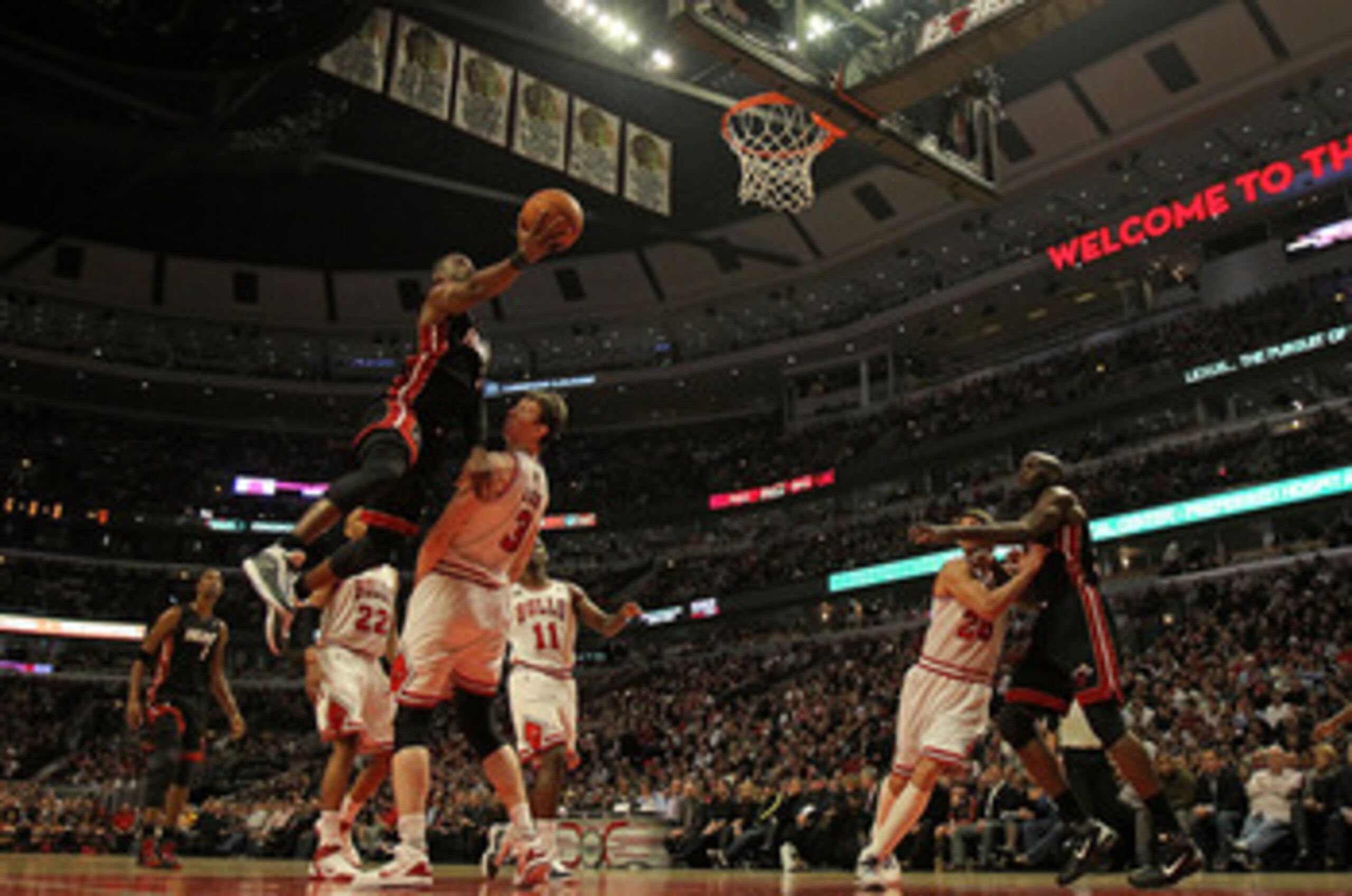 CHICAGO, IL - FEBRUARY 24: Dwyane Wade #3 of of the Miami Heat lepas over Omer Asik #3 of the Chicago Bulls to put up a shot at the United Center on February 24, 2011 in Chicago, Illinois. The Bulls defeated the Heat 93-89. NOTE TO USER: User expressly ac