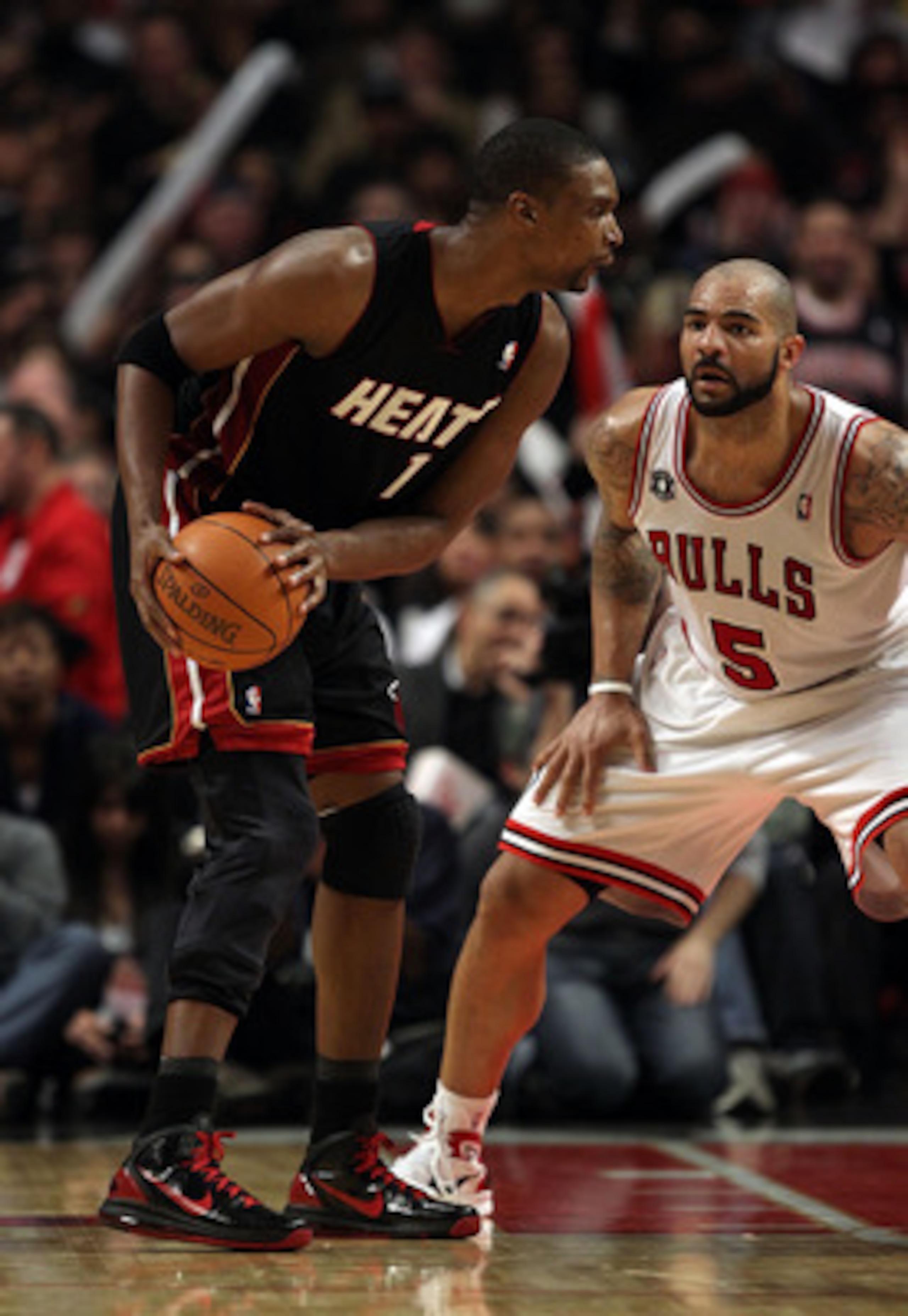 CHICAGO, IL - FEBRUARY 24: Chris Bosh #1 of the Miami Heat looks to moves against Carlos Boozer #5 of the Chicago Bulls at the United Center on February 24, 2011 in Chicago, Illinois. The Bulls defeated the Heat 93-89. NOTE TO USER: User expressly acknowl