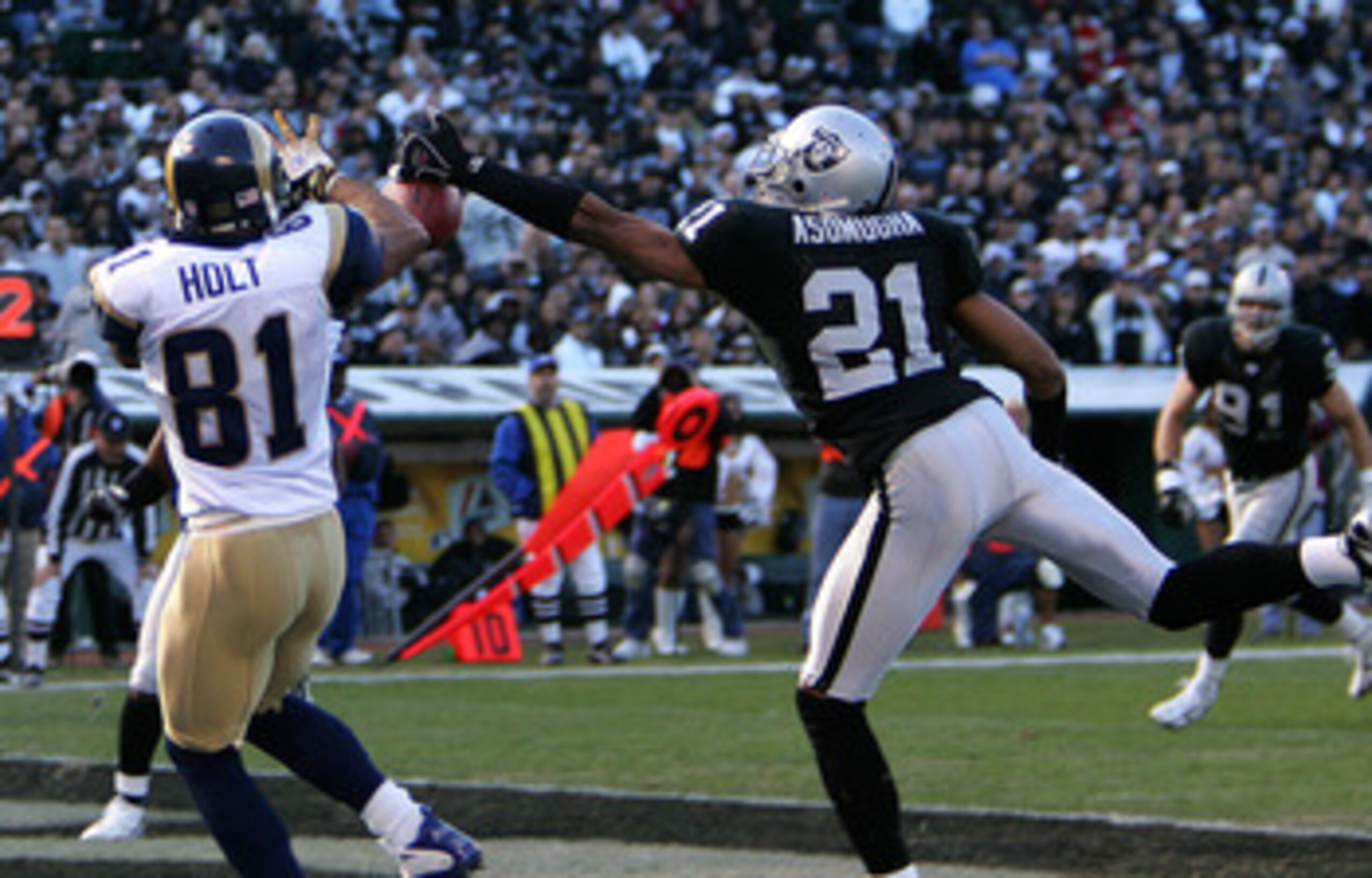 Oakland cornerback Nnamdi Asomugha prevents a touchdown by perfectly deflecting a pass away from St. Louis wide receiver Torry Holt in the Raiders 20-0 loss to the Rams on Sunday, December 17, 2006 at McAfee Coliseum in Oakland, California. (Photo by K. T Oakland cornerback Nnamdi Asomugha prevents a touchdown by perfectly deflecting a pass away from St. Louis wide receiver Torry Holt in the Raiders 20-0 loss to the Rams on Sunday, December 17, 2006 at McAfee Coliseum in Oakland, California. (Photo by K. T