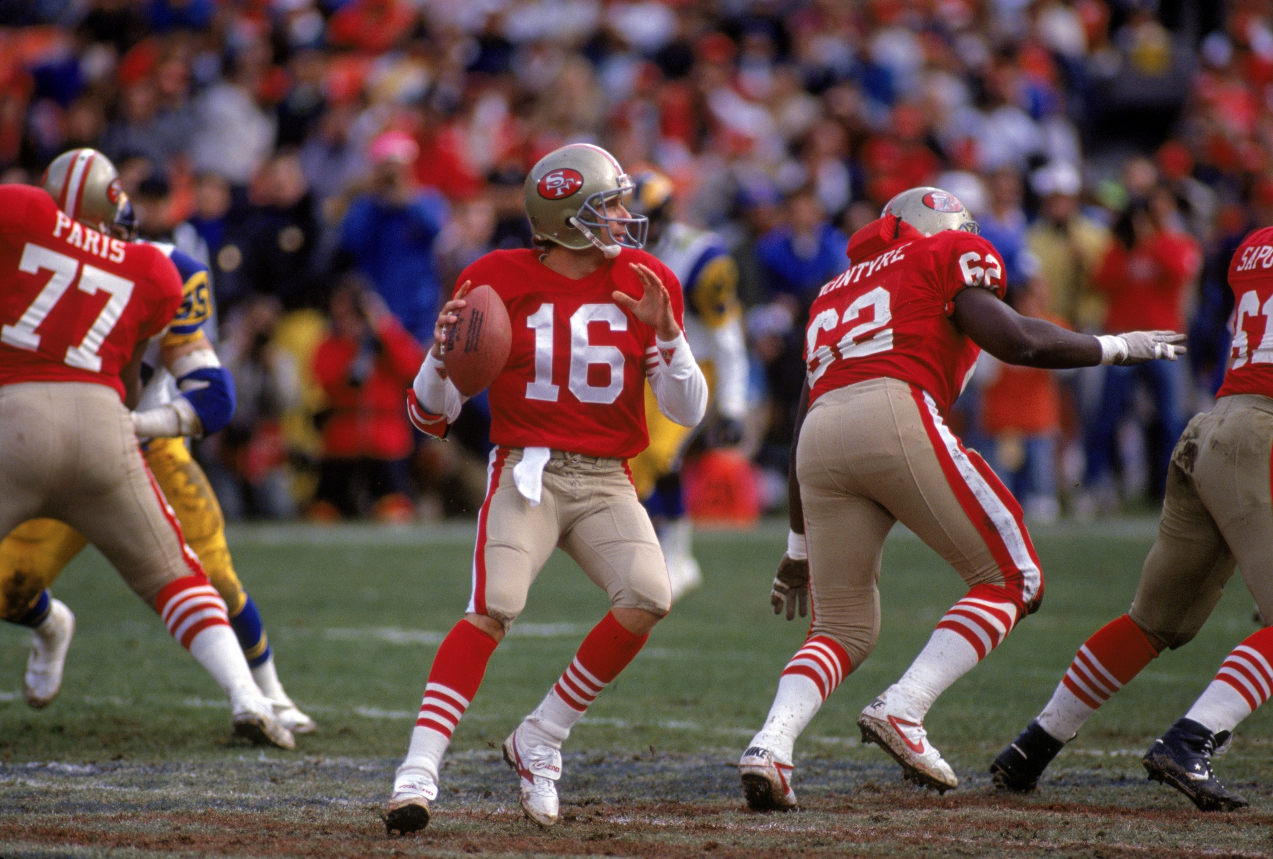 SAN FRANCISCO - JANUARY 14:  Quarterback Joe Montana #16 of the San Francisco 49ers drops back to pass under the protection of offensive tackle Bubba Paris #77 and guard Guy McIntyre #62 during the NFC Championship game against the Los Angeles Rams at Can