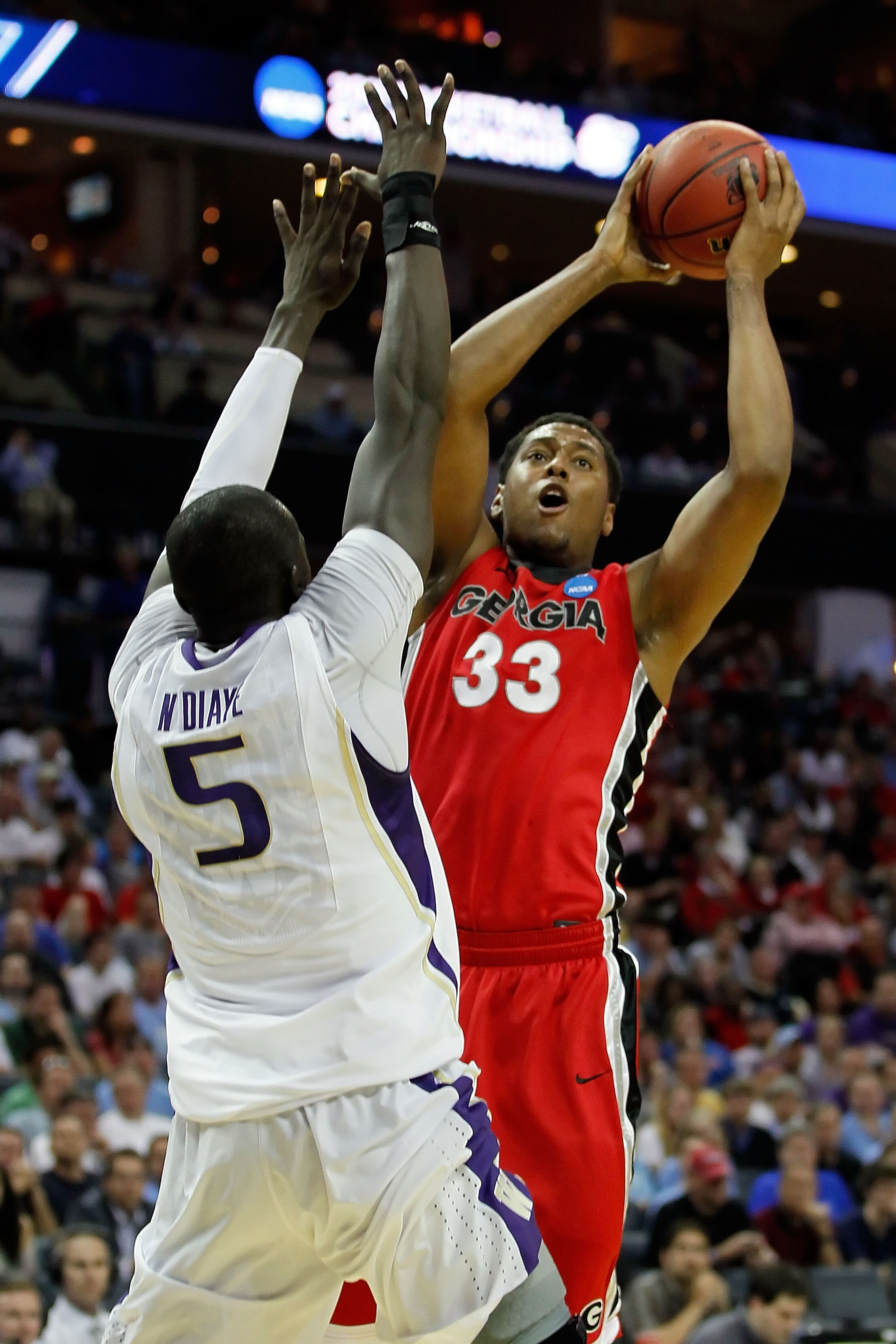 CHARLOTTE, NC - MARCH 18:  Trey Thompkins #33 of the Georgia Bulldogs shoots over Aziz N'Diaye #5 of the Washington Huskies in the first half during the second round of the 2011 NCAA men's basketball tournament at Time Warner Cable Arena on March 18, 2011