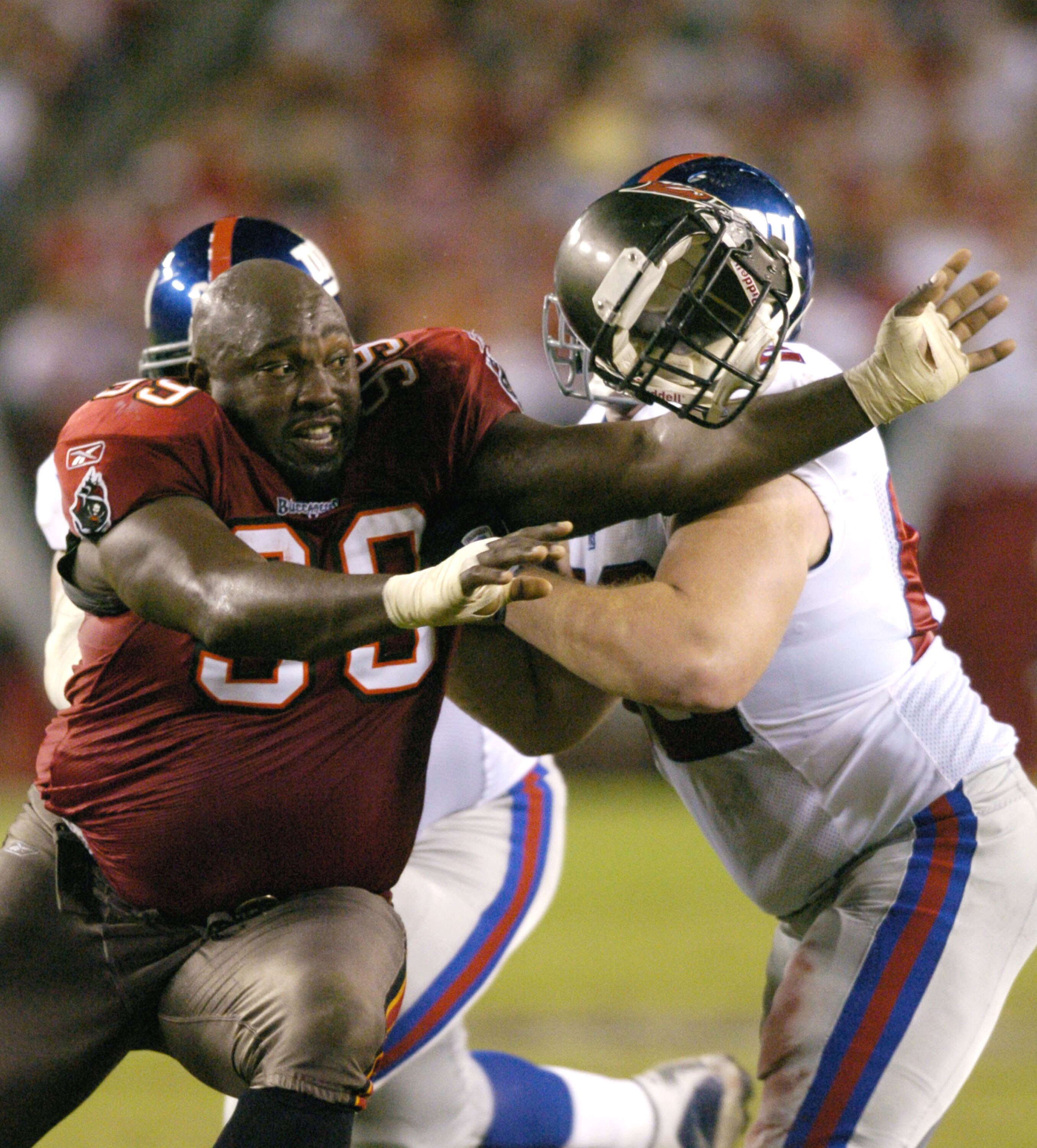 Tampa Bay Buccaneers defensive tackle Warren Sapp loses his helmet while rushing  November 24, 2003 against the New York Giants  at Raymond James Stadium, Tampa.  (Photo by Al Messerschmidt/Getty Images)
