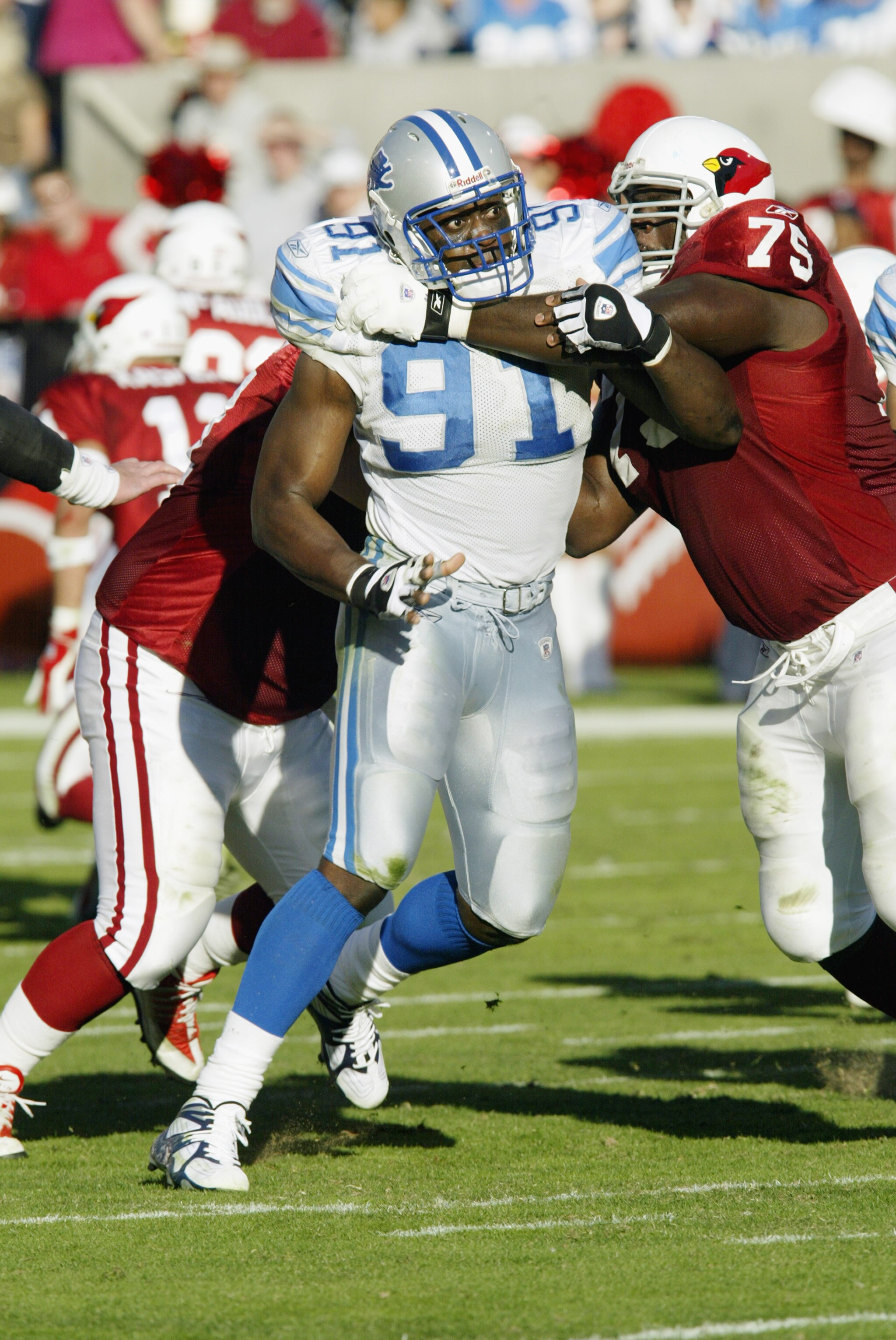 TEMPE, AZ  - DECEMBER 8:  Robert Porcher #91 of the Detroit Lions is tackled by Leonard Davis #75 of the  Arizona Cardinals during the NFL game on December 8, 2002  at Sun Devil Stadium in Tempe, Arizona.. The Cardinals won in overtime 23-20.   (Photo by
