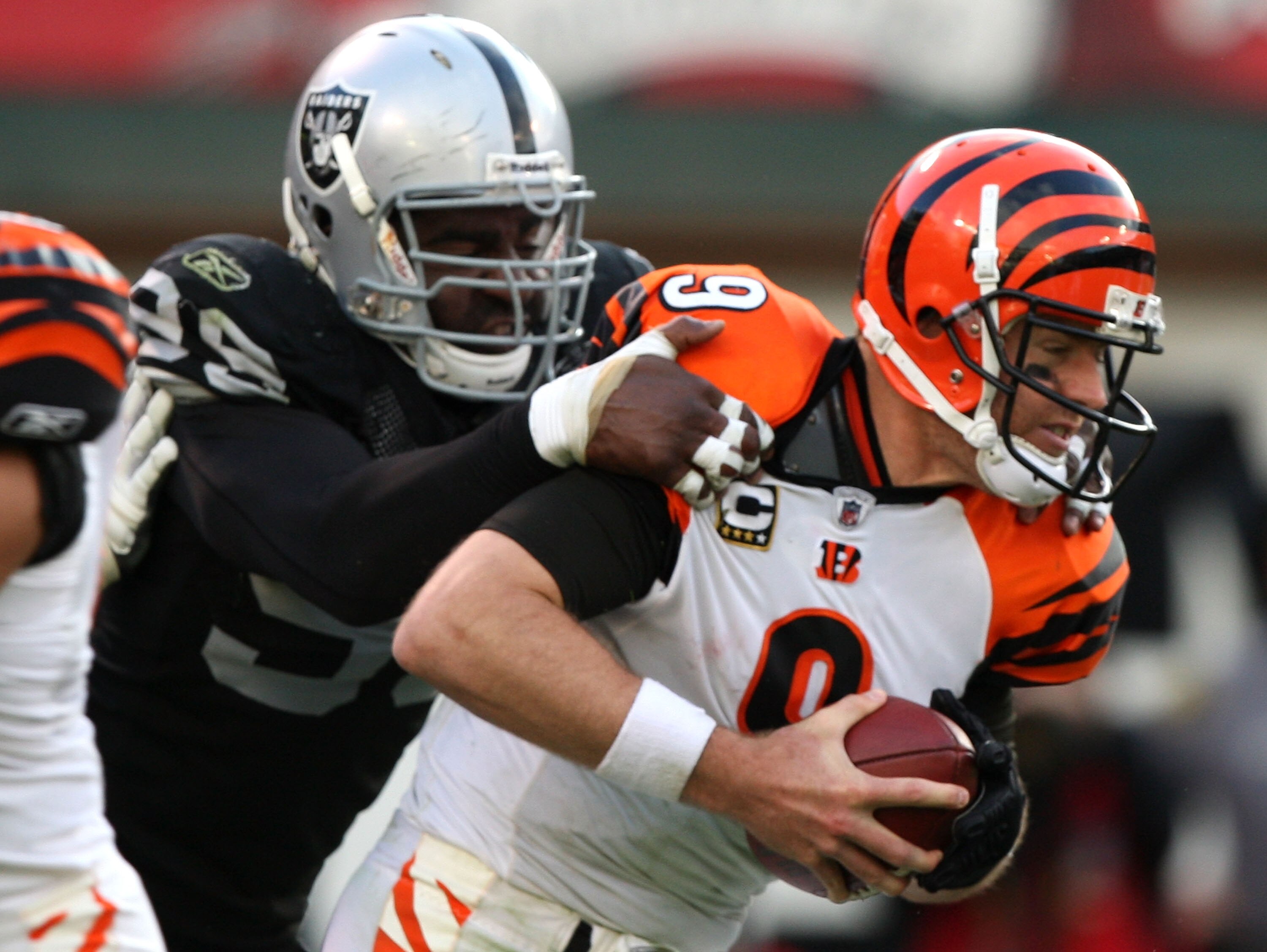 OAKLAND, CA - NOVEMBER 22:  Carson Palmer #9 of the Cincinnati Bengals is sacked by Greg Ellis #99 of the Oakland Raiders during an NFL game at Oakland-Alameda County Coliseum on November 22, 2009 in Oakland, California.  (Photo by Jed Jacobsohn/Getty Ima