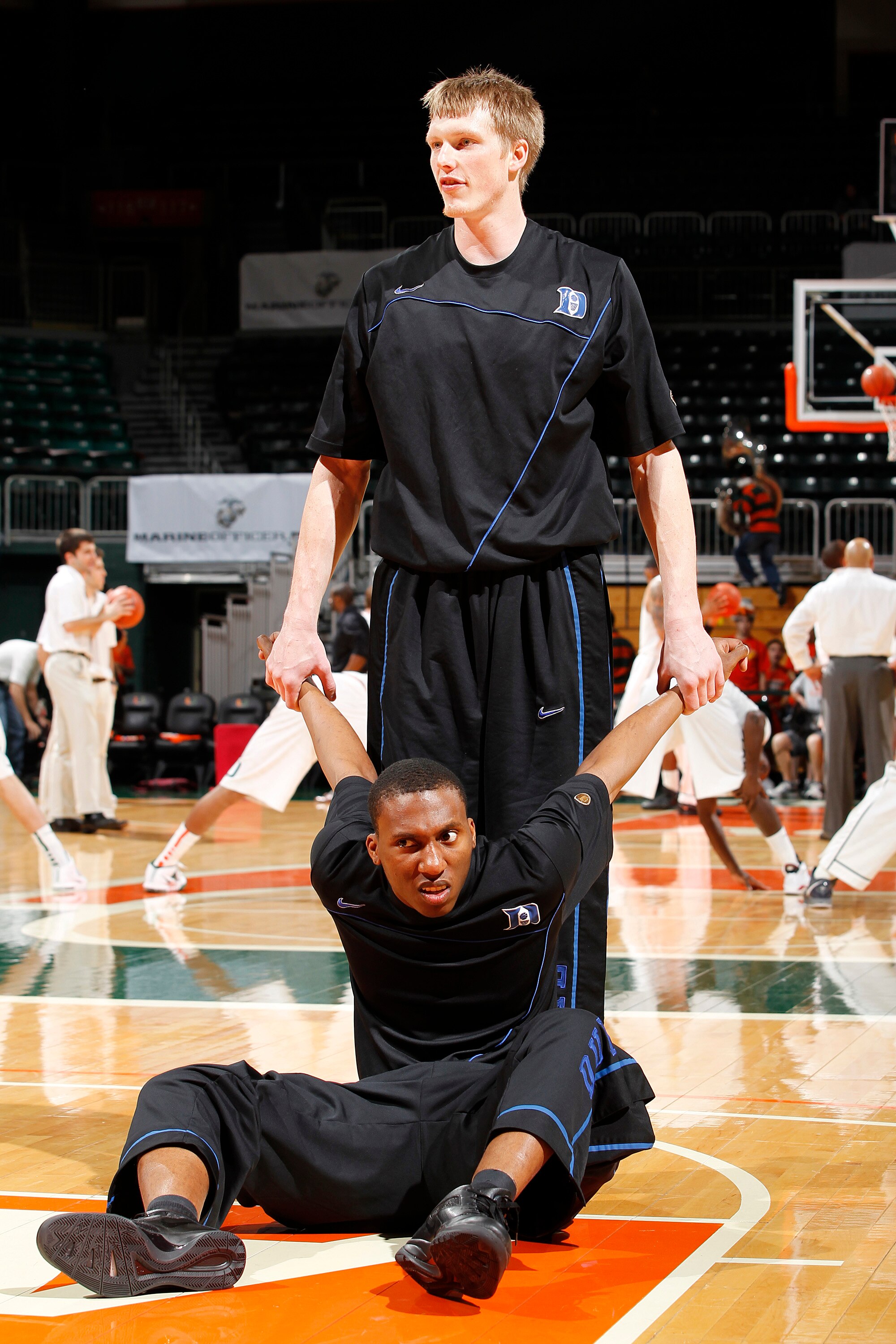 CORAL GABLES, FL - FEBRUARY 13: Kyle Singler #12 (standing) helps Nolan Smith #2 of the Duke Blue Devils stretch prior to the NCAA game against the Miami Hurricanes on February 13, 2011 at the BankUnited Center in Coral Gables, Florida. (Photo by Joel Aue