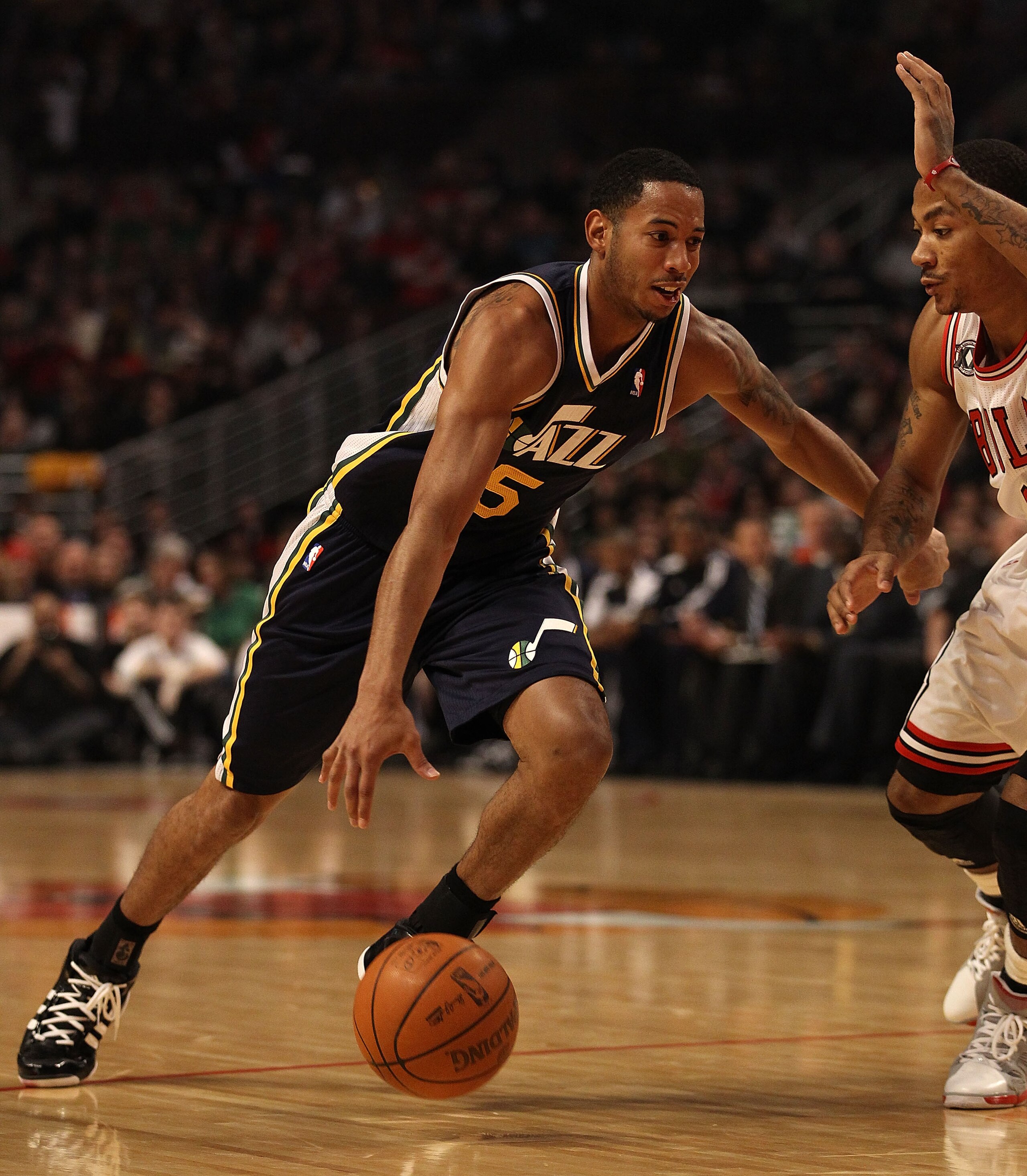 CHICAGO, IL - MARCH 12: Devin Harris #5 of the Utah Jazz drives against Derrick Rose #1 of the Chicago Bulls at the United Center on March 12, 2011 in Chicago, Illinois. The Bulls defeated the Jazz 118-100. NOTE TO USER: User expressly acknowledges and ag