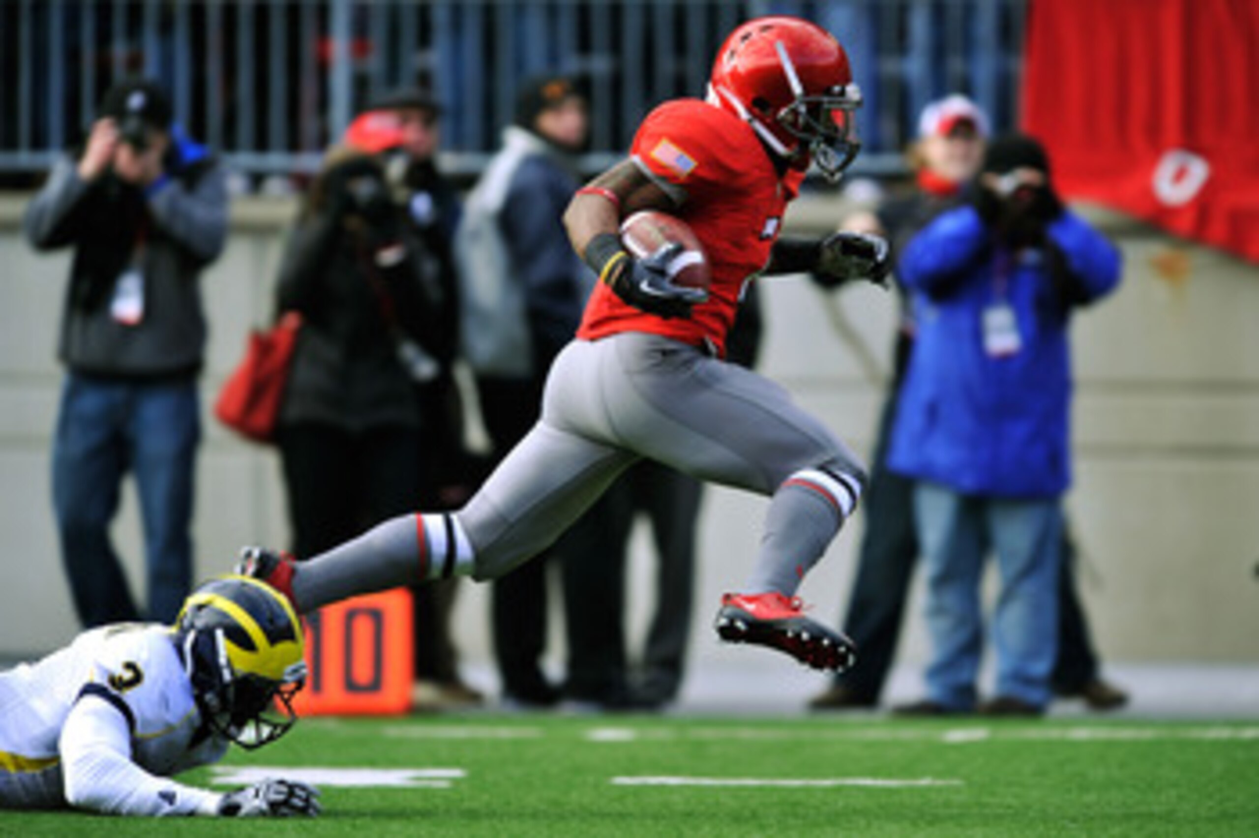 COLUMBUS, OH - NOVEMBER 27:  Jordan Hall #7 of the Ohio State Buckeyes eludes the tackle attempt of Marvin Robinson #3 of the Michigan Wolverines on his way to an 85-yard kick return for a touchdown in the second quarter at Ohio Stadium on November 27, 20