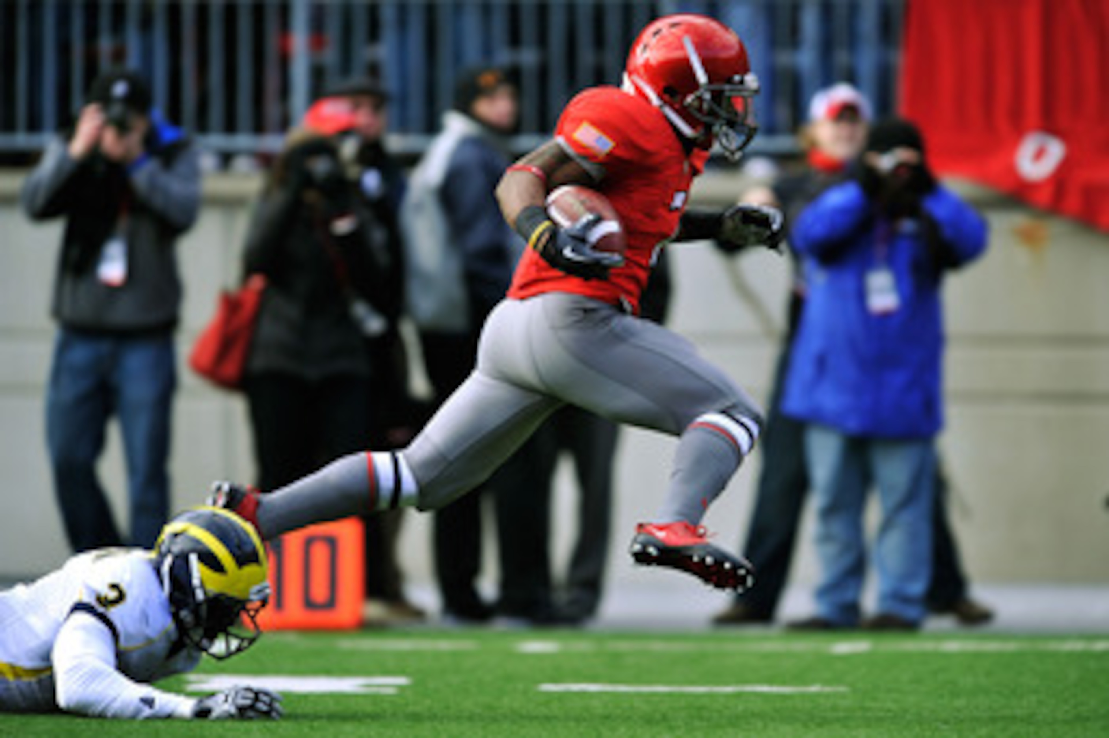 COLUMBUS, OH - NOVEMBER 27:  Jordan Hall #7 of the Ohio State Buckeyes eludes the tackle attempt of Marvin Robinson #3 of the Michigan Wolverines on his way to an 85-yard kick return for a touchdown in the second quarter at Ohio Stadium on November 27, 20