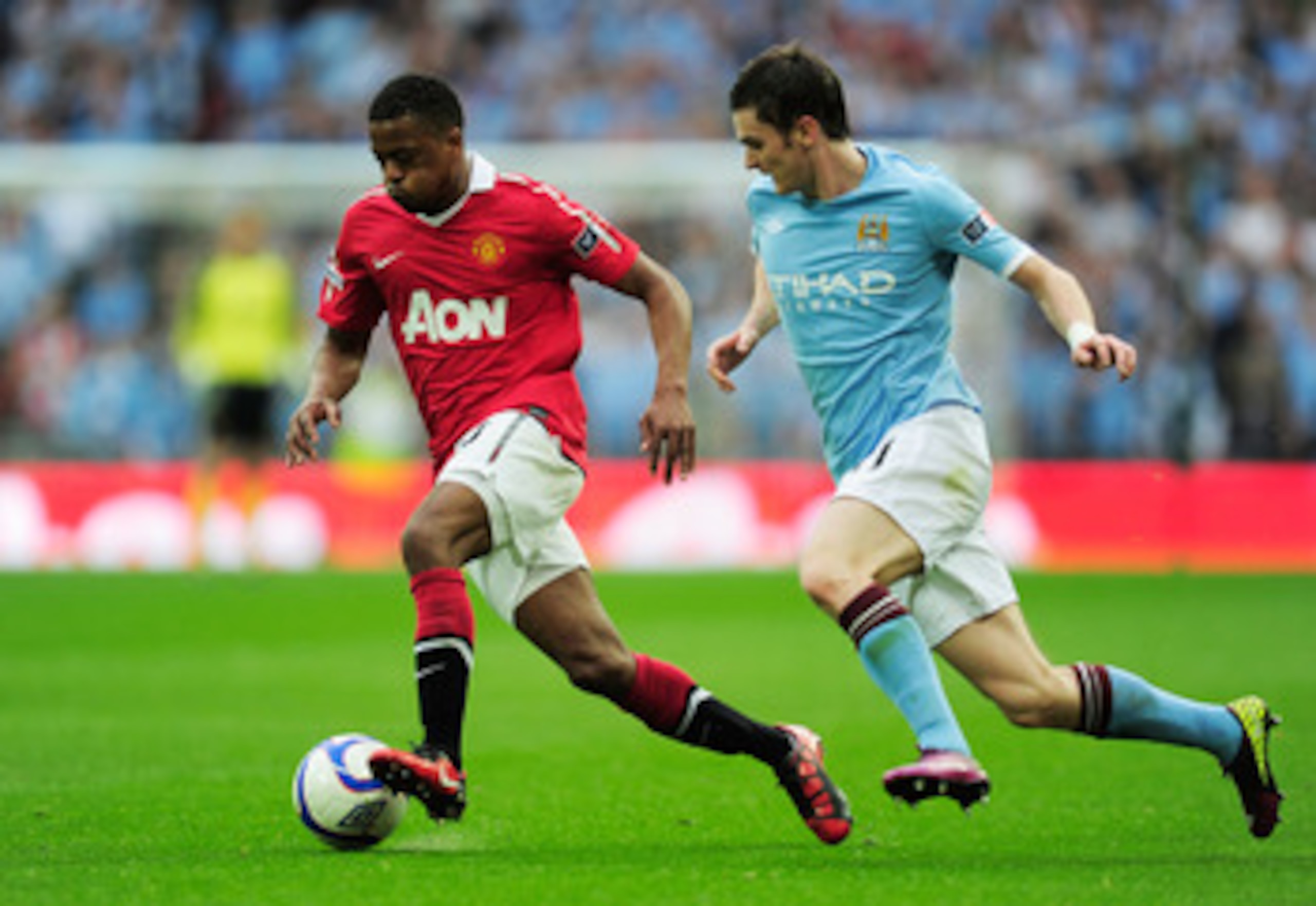 LONDON, ENGLAND - APRIL 16:  Adam Johnson of Manchester City chases down Patrice Evra of Manchester United during the FA Cup sponsored by E.ON semi final match between Manchester City and Manchester United at Wembley Stadium on April 16, 2011 in London, E