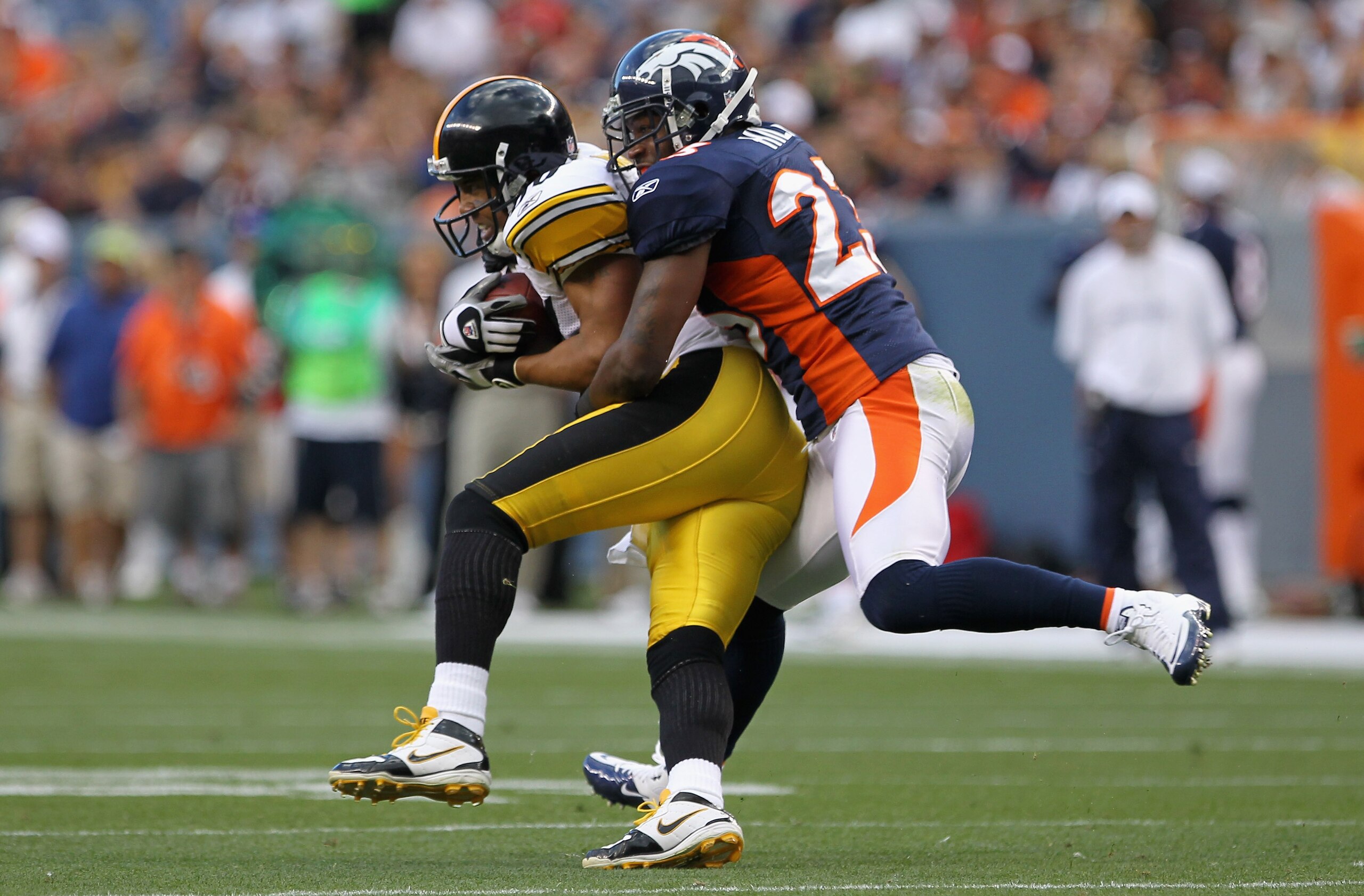 DENVER - AUGUST 29:  Wide receiver Hines Ward #86 of the Pittsburgh Steelers makes a reception and is tackled by safety Renaldo Hill #23 of the Denver Broncos during preseason NFL action at INVESCO Field at Mile High on August 29, 2010 in Denver, Colorado