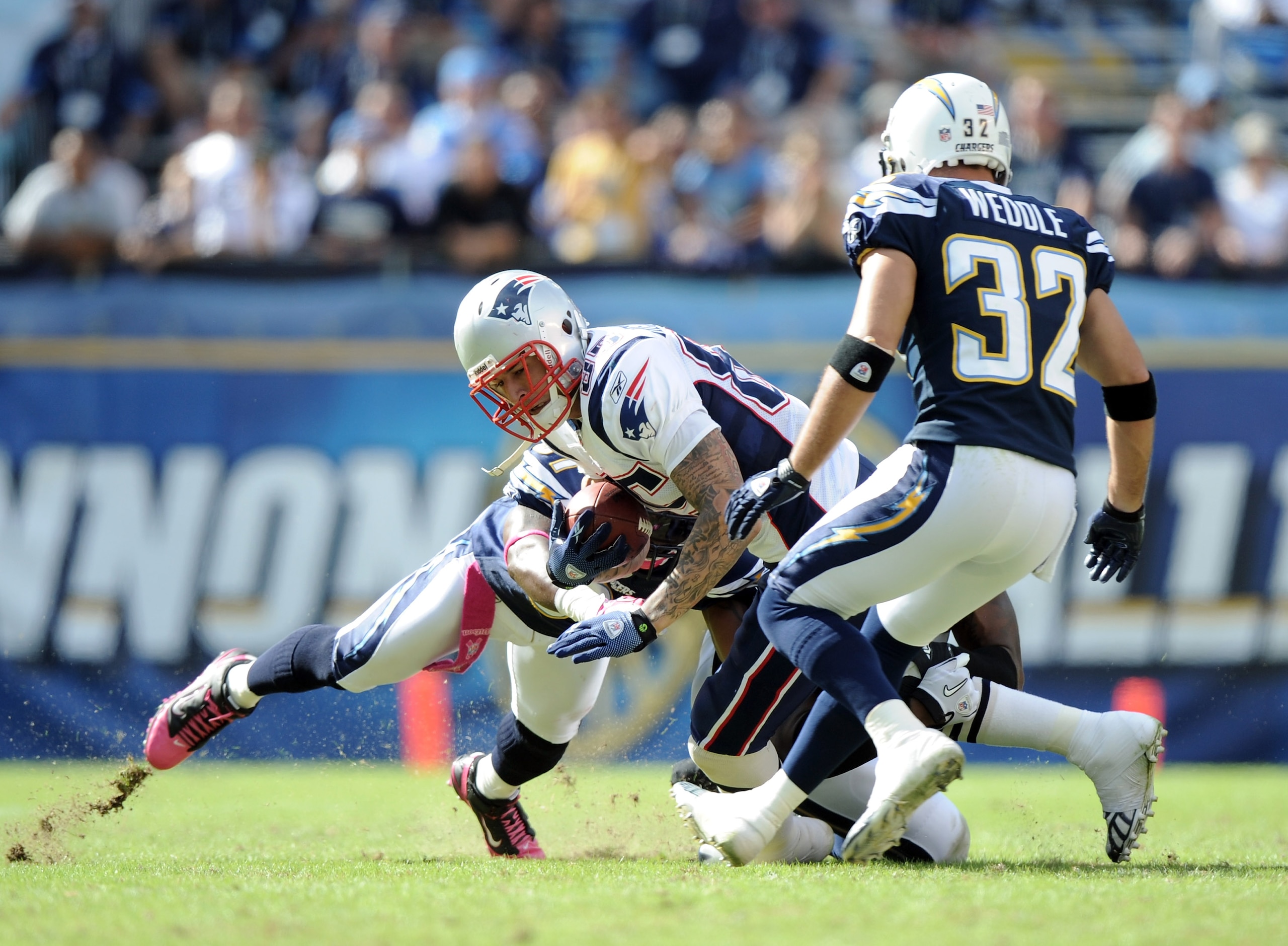 SAN DIEGO - OCTOBER 24:  Aaron Hernandez #85 of the New England Patriots is tackled by Tyrone Carter #21 and Eric Weddle #32 of the San Diego Chargers at Qualcomm Stadium on October 24, 2010 in San Diego, California.  (Photo by Harry How/Getty Images)