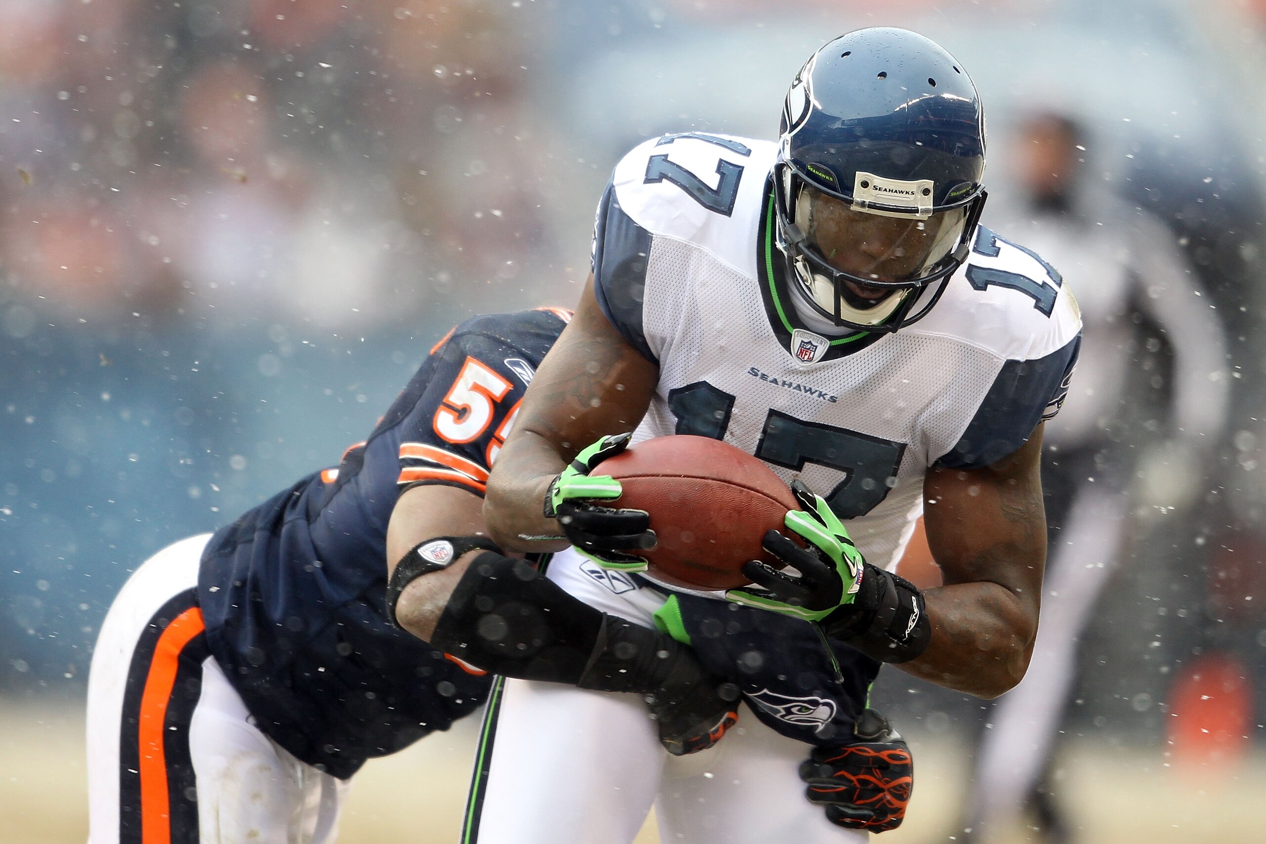 CHICAGO, IL - JANUARY 16:  Wide receiver Mike Williams #17 of the Seattle Seahawks makes a catch as he is tackled by Lance Briggs #55 of the Chicago Bears in the second quarter of the 2011 NFC divisional playoff game at Soldier Field on January 16, 2011 i