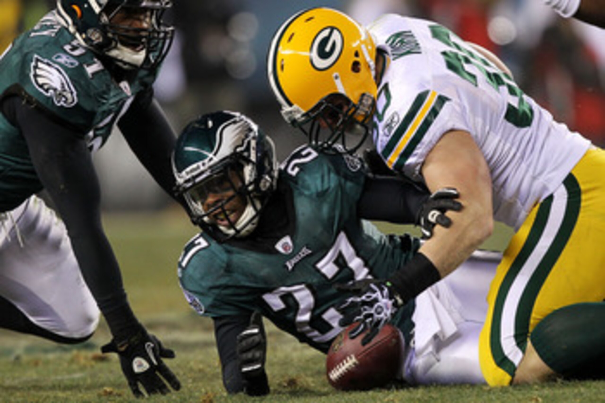 PHILADELPHIA, PA - JANUARY 09:  John Kuhn #30 of the Green Bay Packers fights for a fumble against Quintin Mikell #27 and Jamar Chaney #51 of the Philadelphia Eagles during the 2011 NFC wild card playoff game at Lincoln Financial Field on January 9, 2011